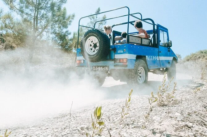 4x4 jeep driving through forested mountain roads in Sintra with dense greenery and rugged terrain