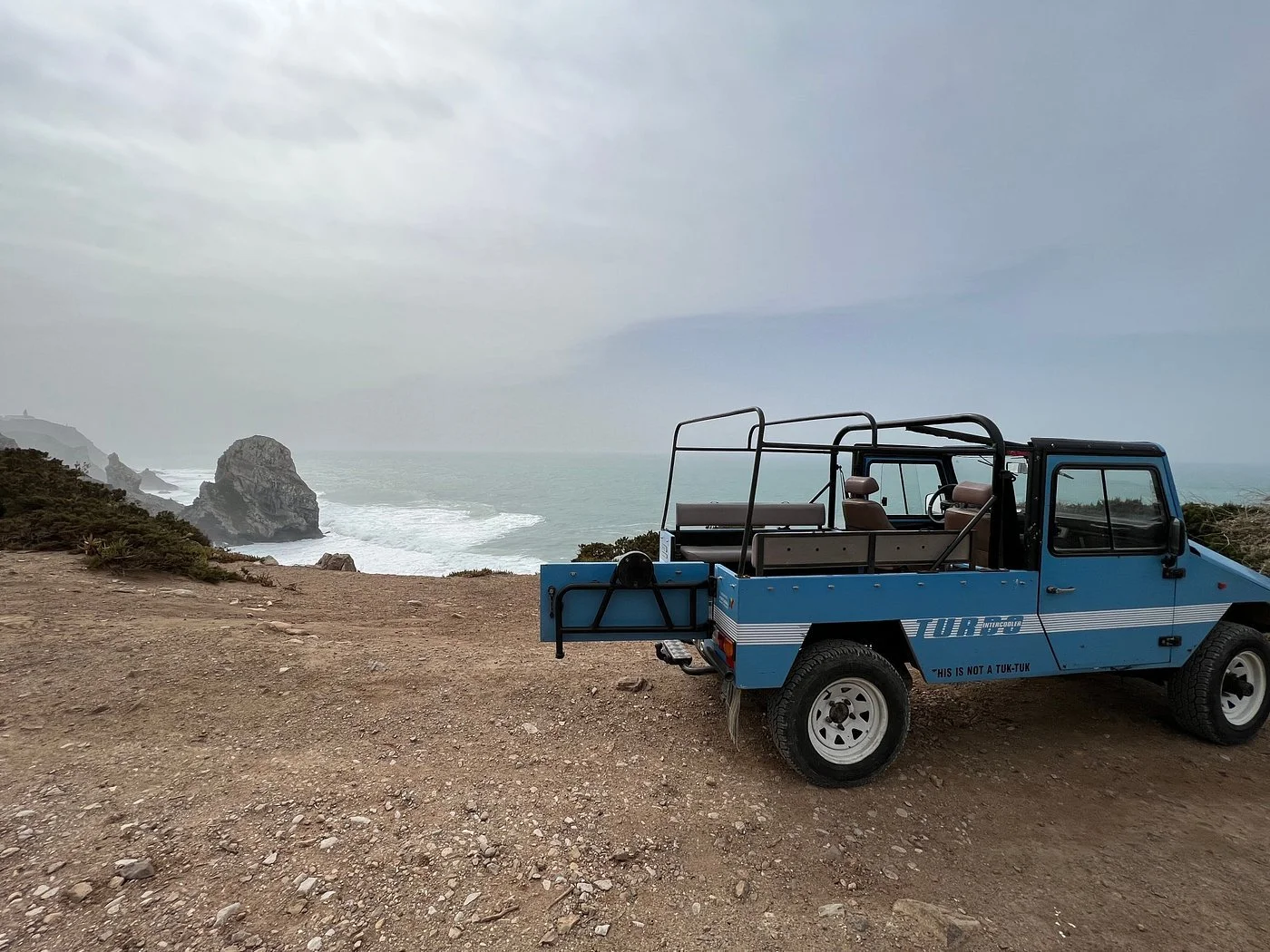 4x4 jeep parked at a scenic viewpoint in Sintra overlooking the Atlantic Ocean and coastal cliffs