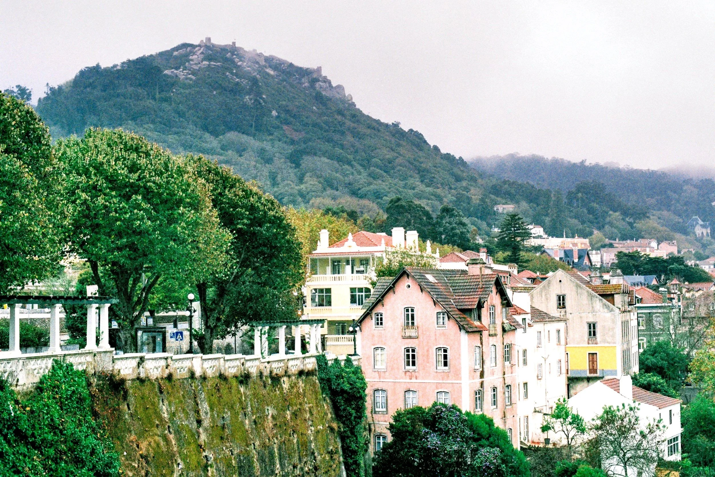Scenic view of Sintra town with colorful buildings and forested mountains in the background