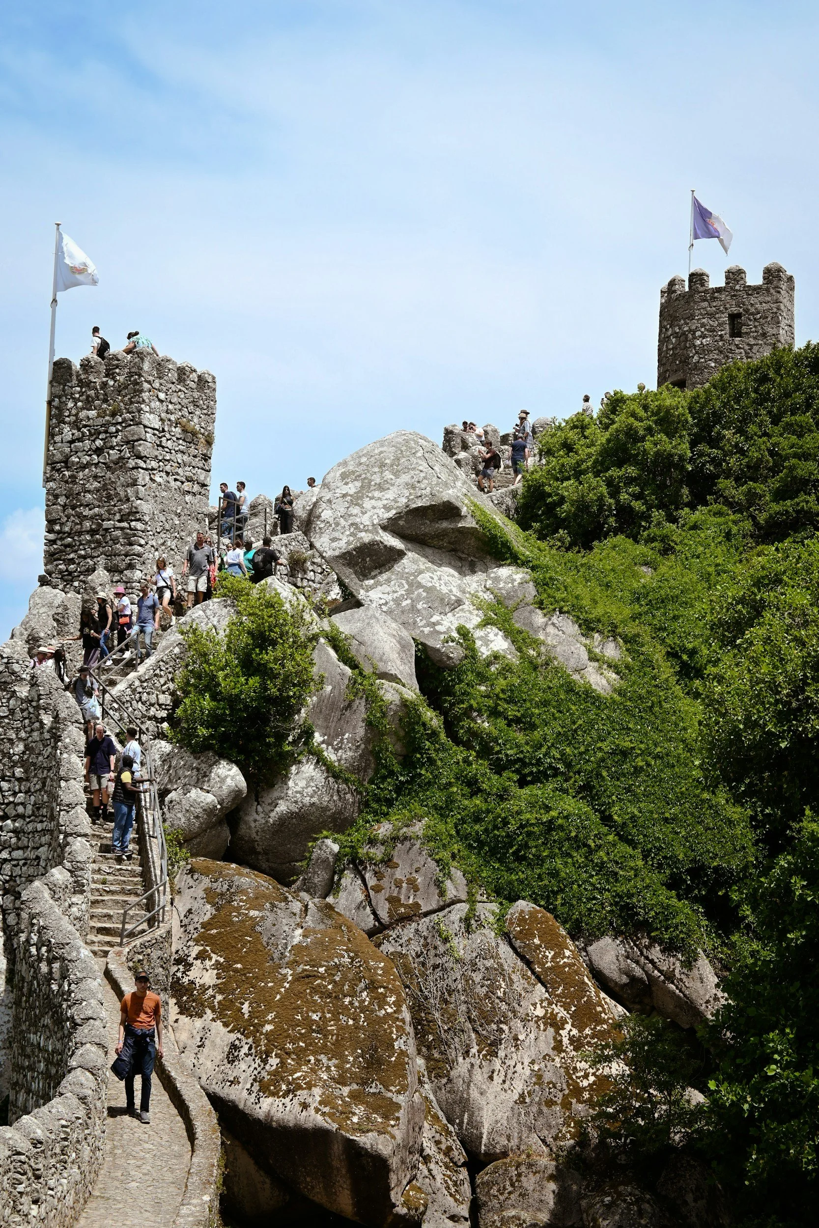 Visitors walking along the walls of the Moorish Castle in Sintra with panoramic views of the surrounding hills
