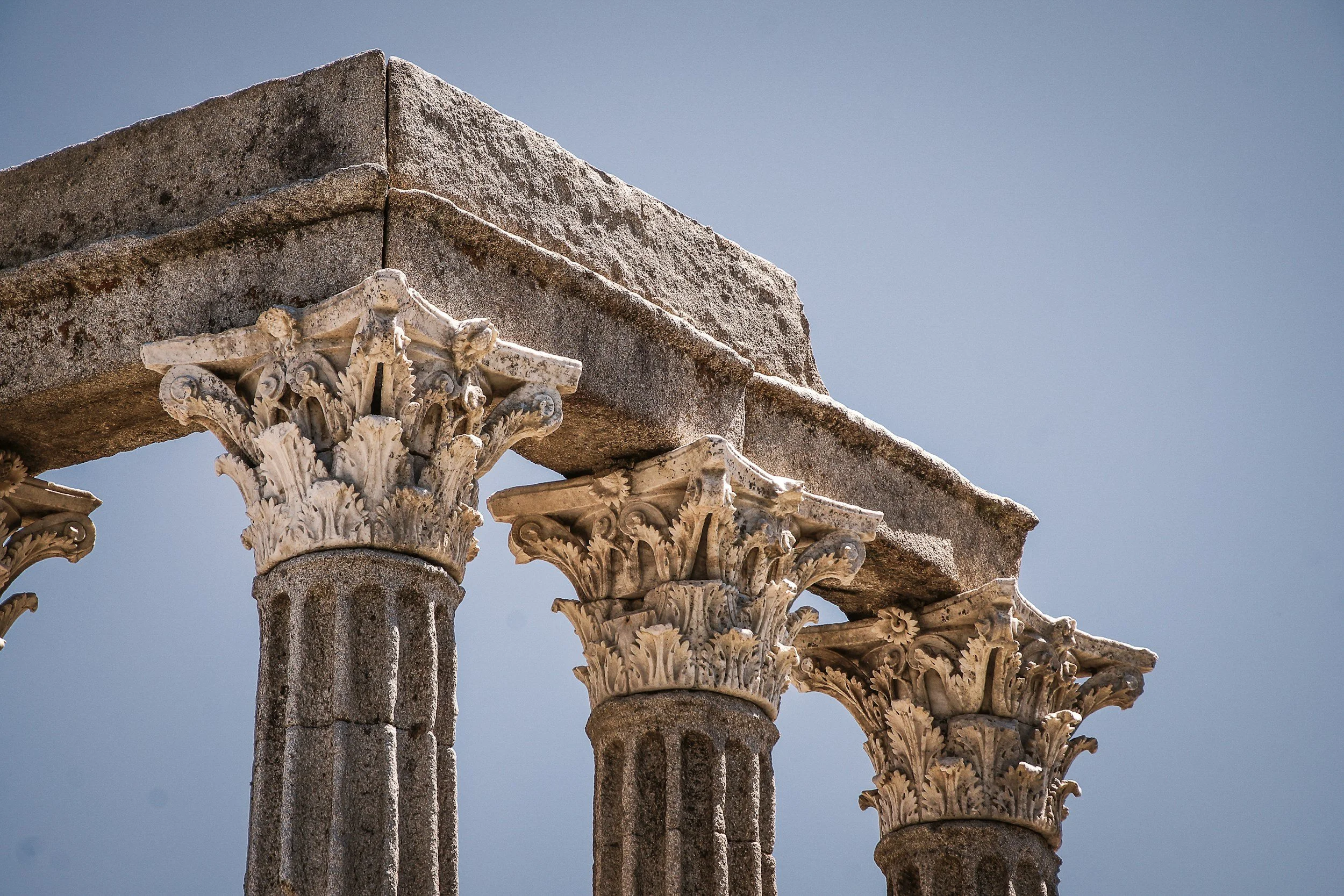 Upper section of columns at the Roman Temple of Évora against the sky