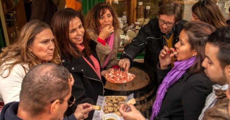 Friends sampling authentic Portuguese food on the Lisbon Food and Culture Walk