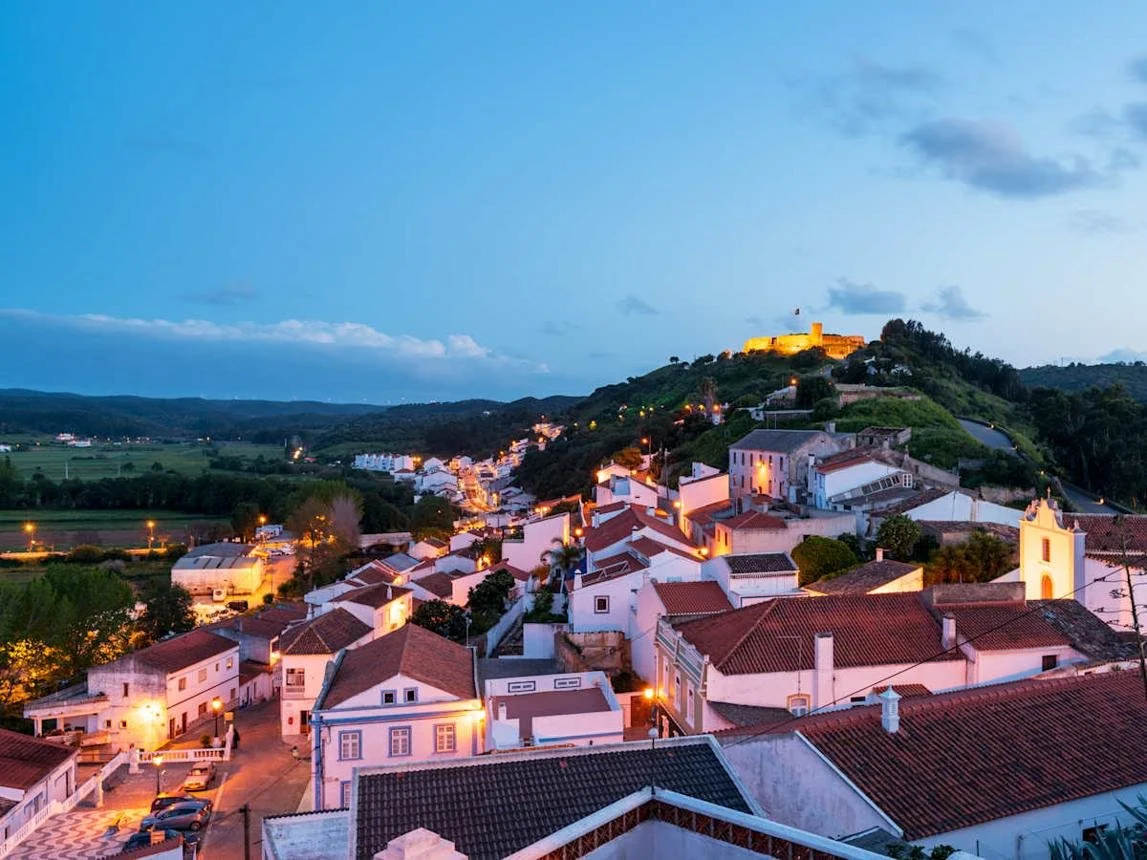 Hilltop ruins of Aljezur Castle overlooking the whitewashed village and green countryside of Portugal’s western Algarve at night