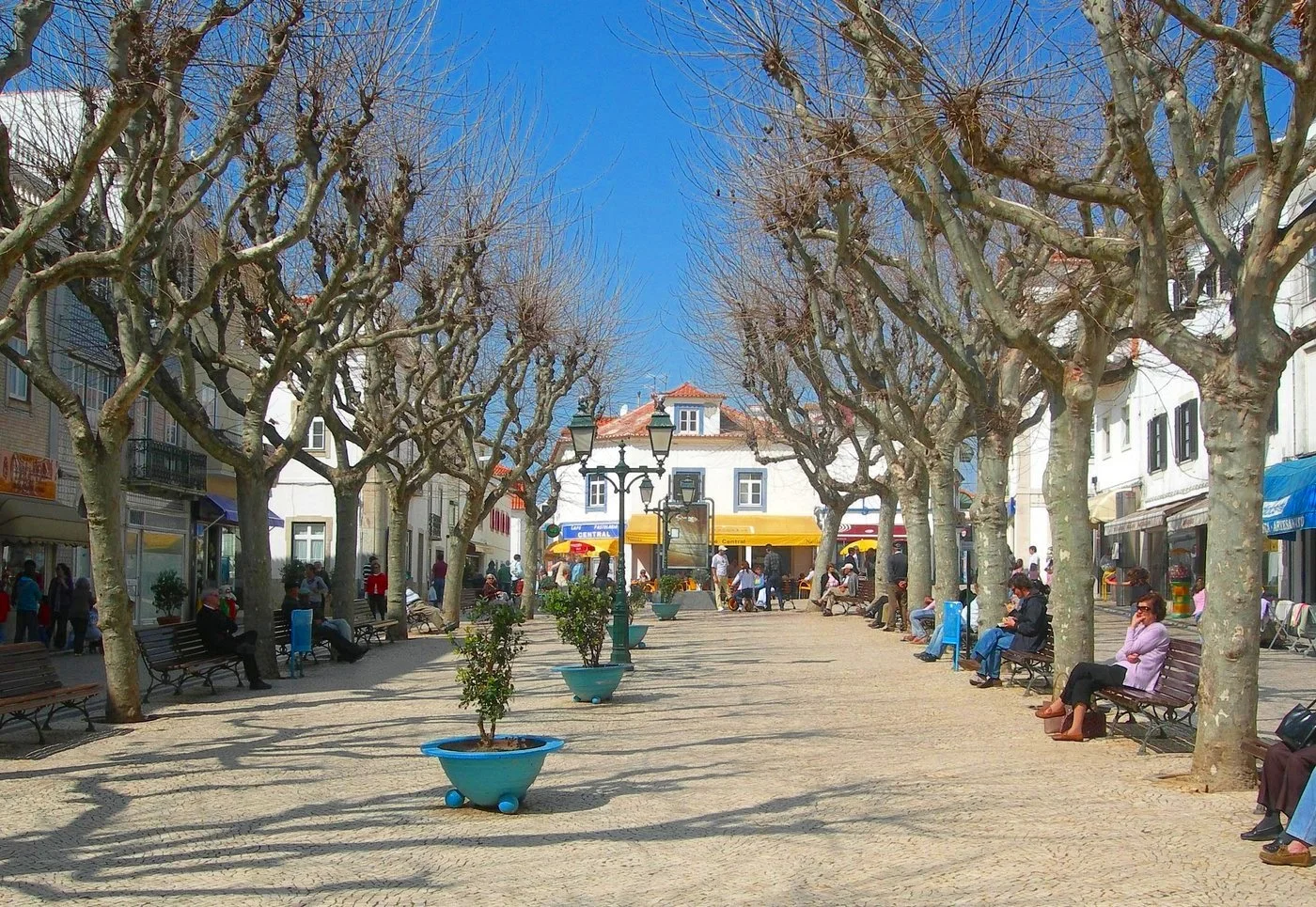 Praça do Jogo da Bola Town Square in Ericeira, Portugal: Cafes, Gelaterias, and Shops Surrounding a Charming Public Space.