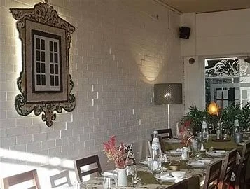 Casual elegance table setting at Taska Lusa in Estoril, featuring beautifully arranged tableware, vibrant Portuguese ceramics, and stylish glassware, creating the perfect atmosphere for enjoying authentic Portuguese cuisine.