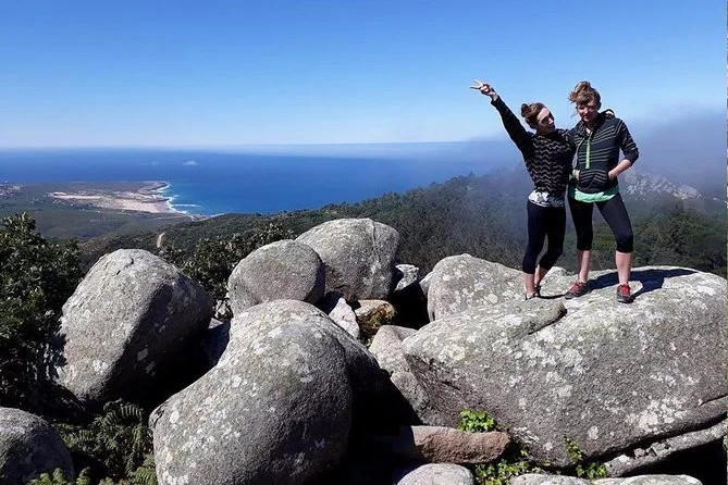Nature enthusiasts capturing the stunning view from their ascent to a mountain peak in the Sintra-Cascais National Park, a must-visit destination for outdoor adventures in Portugal.