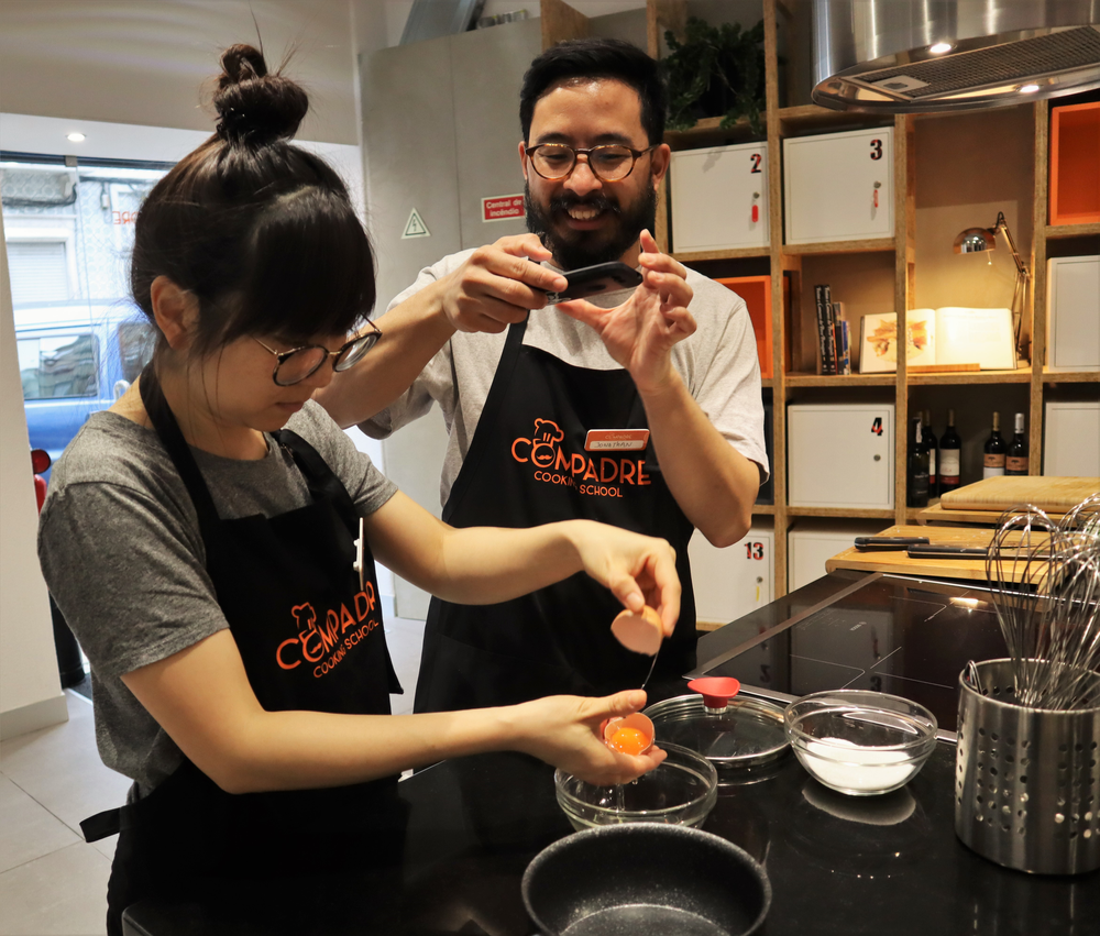 A couple having fun preparing traditional Portuguese food during theHands on Portuguese Cooking Class of Traditional Dishes