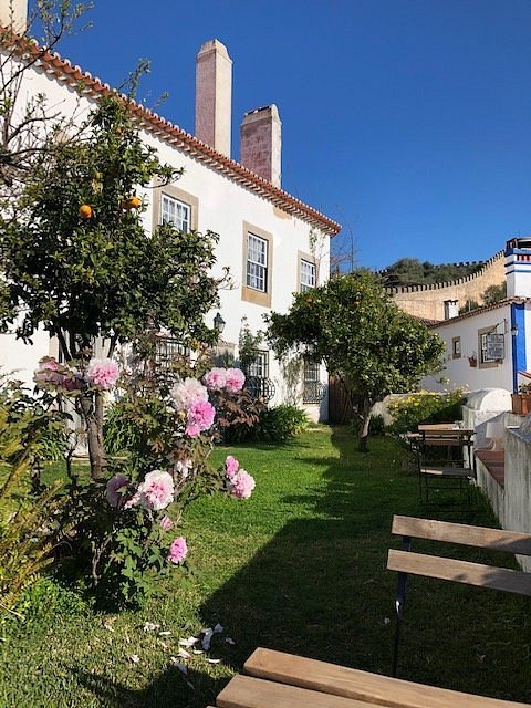 Charming Guesthouse at Casa Picva, Obidos: Cozy Accommodation with Chimneys, Garden, Pink Flowering Bushes, and Orange Trees..