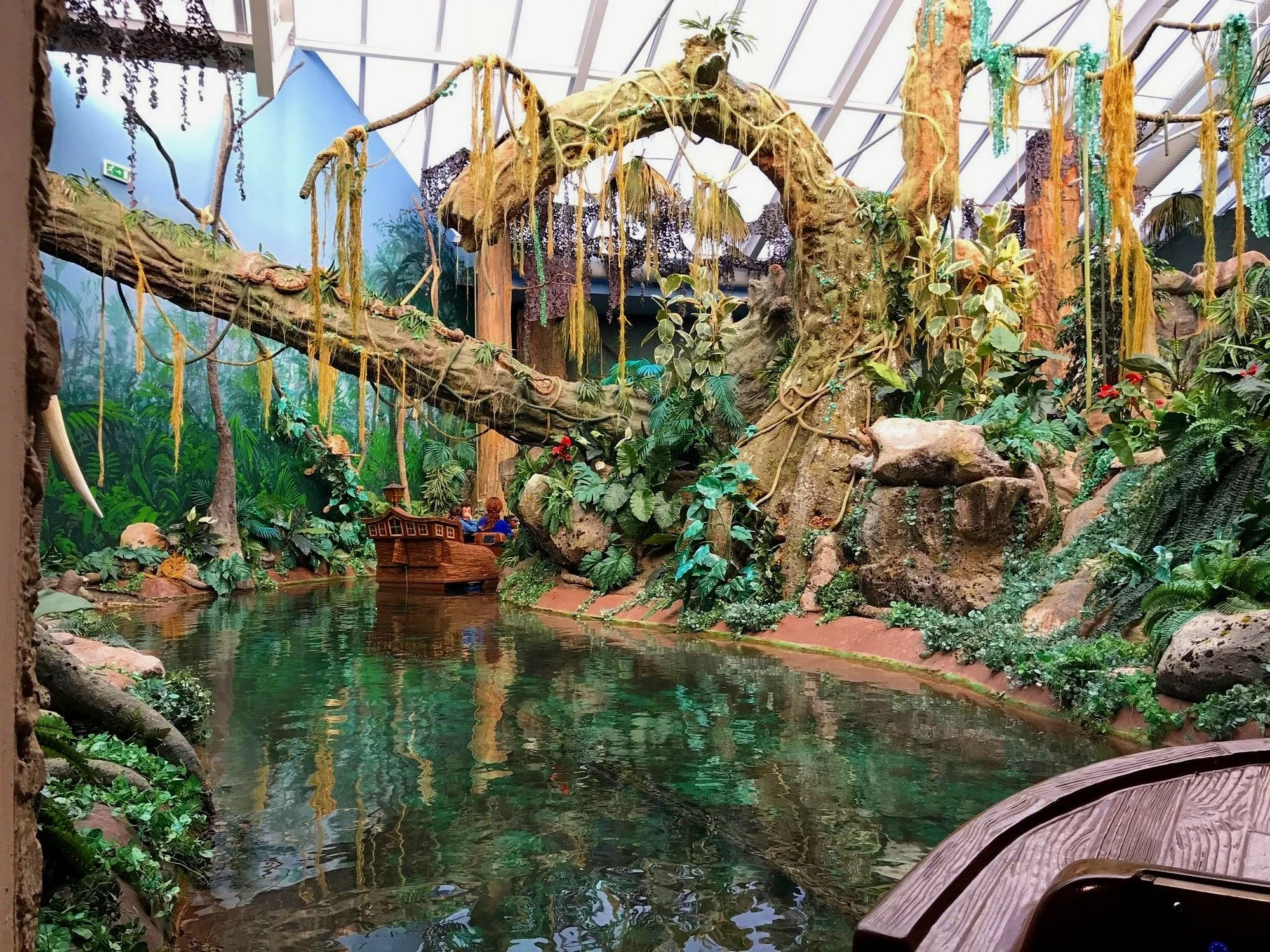 World of Discoveries Museum, Porto: Indoor Jungle-Themed Water Ride with Lush Vegetation and Decorative Boat.
