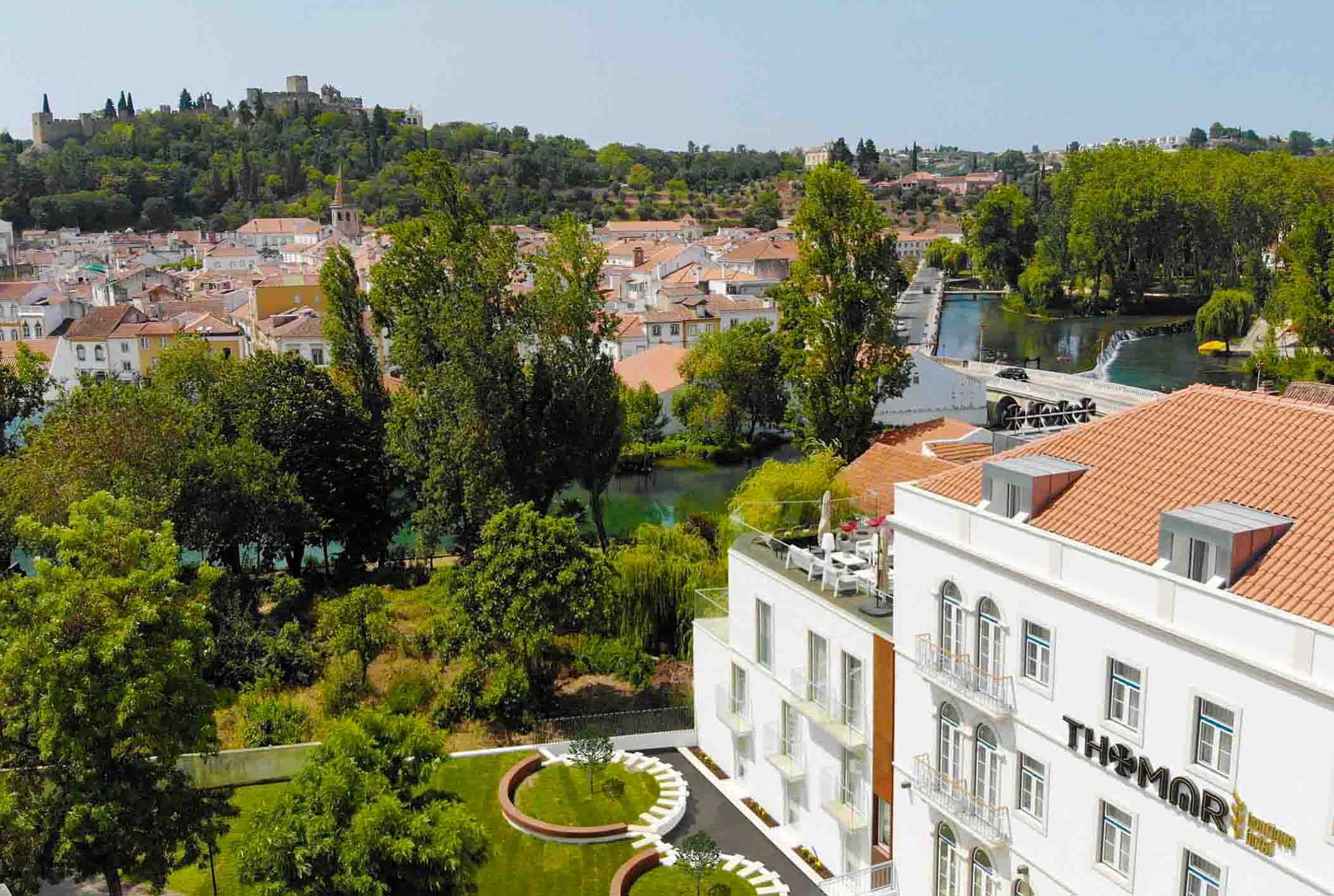 Aerial View of Tomar from Thomar Boutique Hotel: Historic Architecture, Lush Greenery, and Scenic River Landscape.