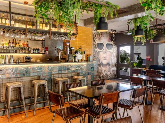 The interior of Mana restaurant in historic Cascais features a casual, eclectic, and creative vibe with vibrant colors and unique decor. This inviting space offers a warm and welcoming atmosphere, perfect for enjoying flavorful dishes.