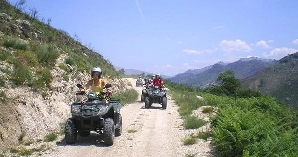 Gerês National Park: ATV Riders on Dirt Trail in Mountainous Terrain Under a Clear Blue Sky