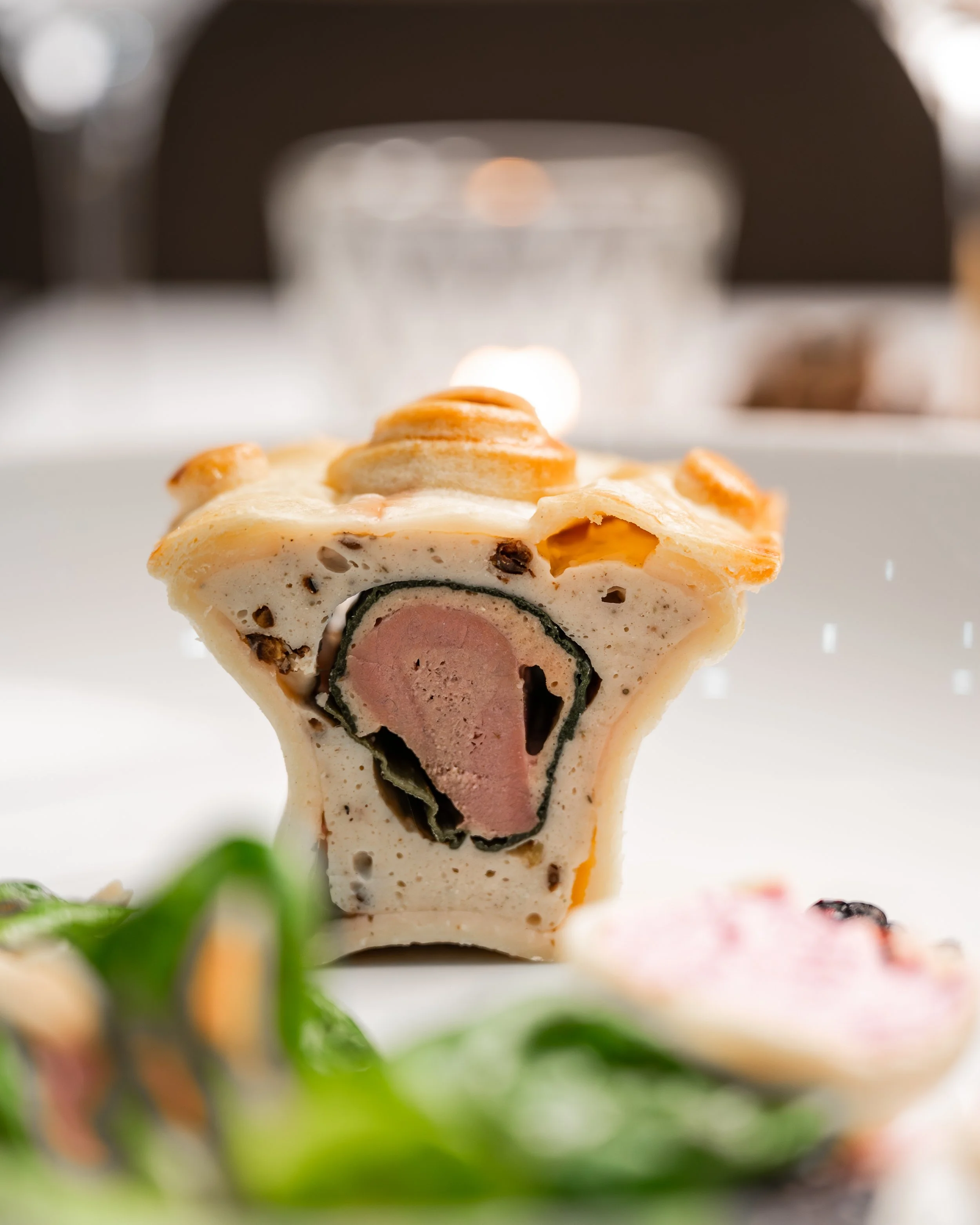 Gourmet Gericht mit grünem Salat auf einem weißen Teller. 