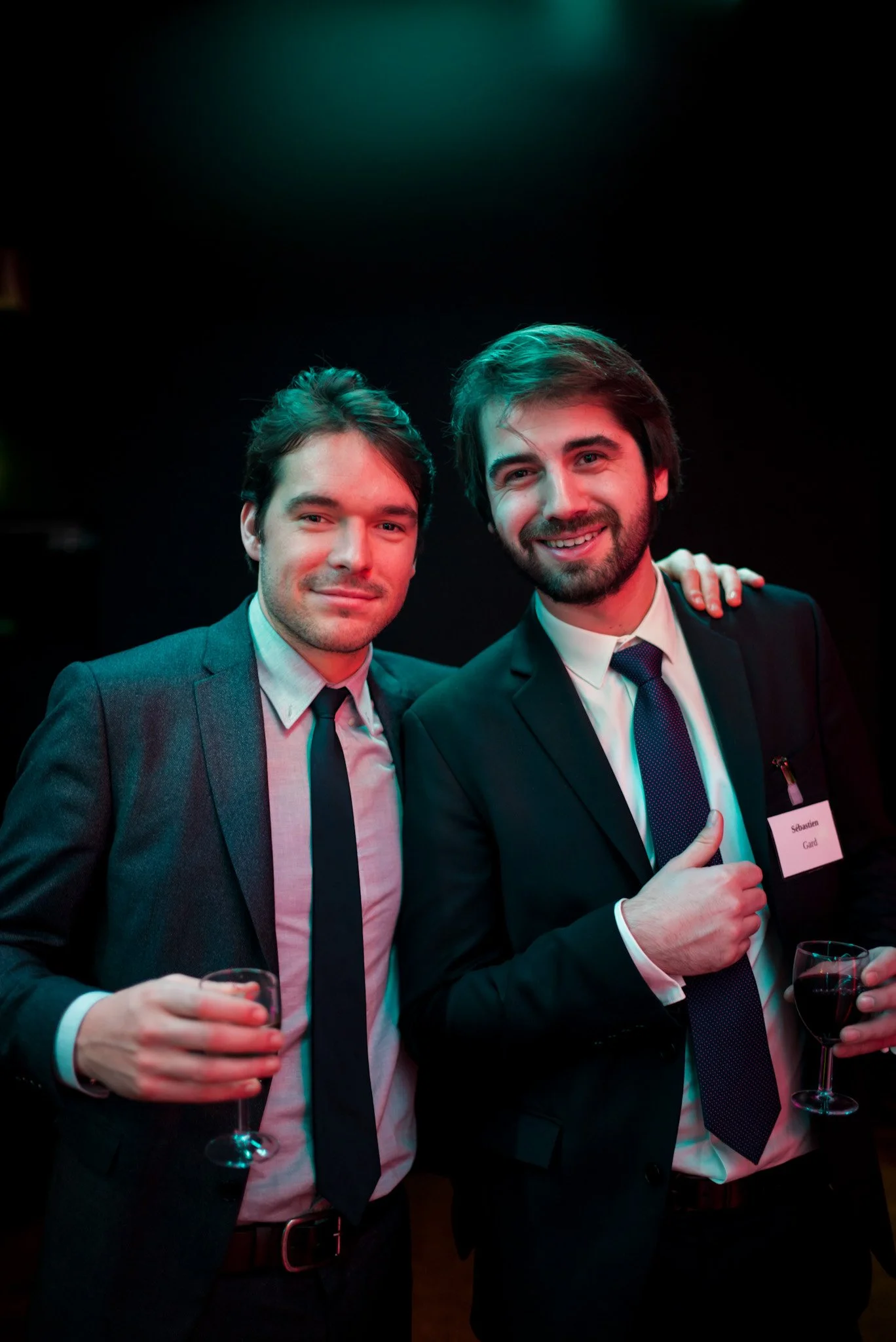 Sébastien Gard et un collègue posent avec des verres de vin lors de la soirée Régus Paris. Tenues formelles, sourires complices, illustrant le networking élégant et professionnel de la soirée.