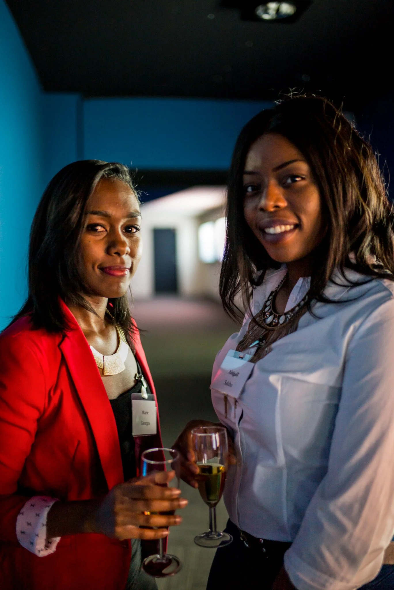 Marie Georges et Abigail Sakho discutent avec des verres de champagne lors de la soirée Régus. Tenues professionnelles et élégantes, illustrant le networking féminin et les échanges de qualité de l'événement.