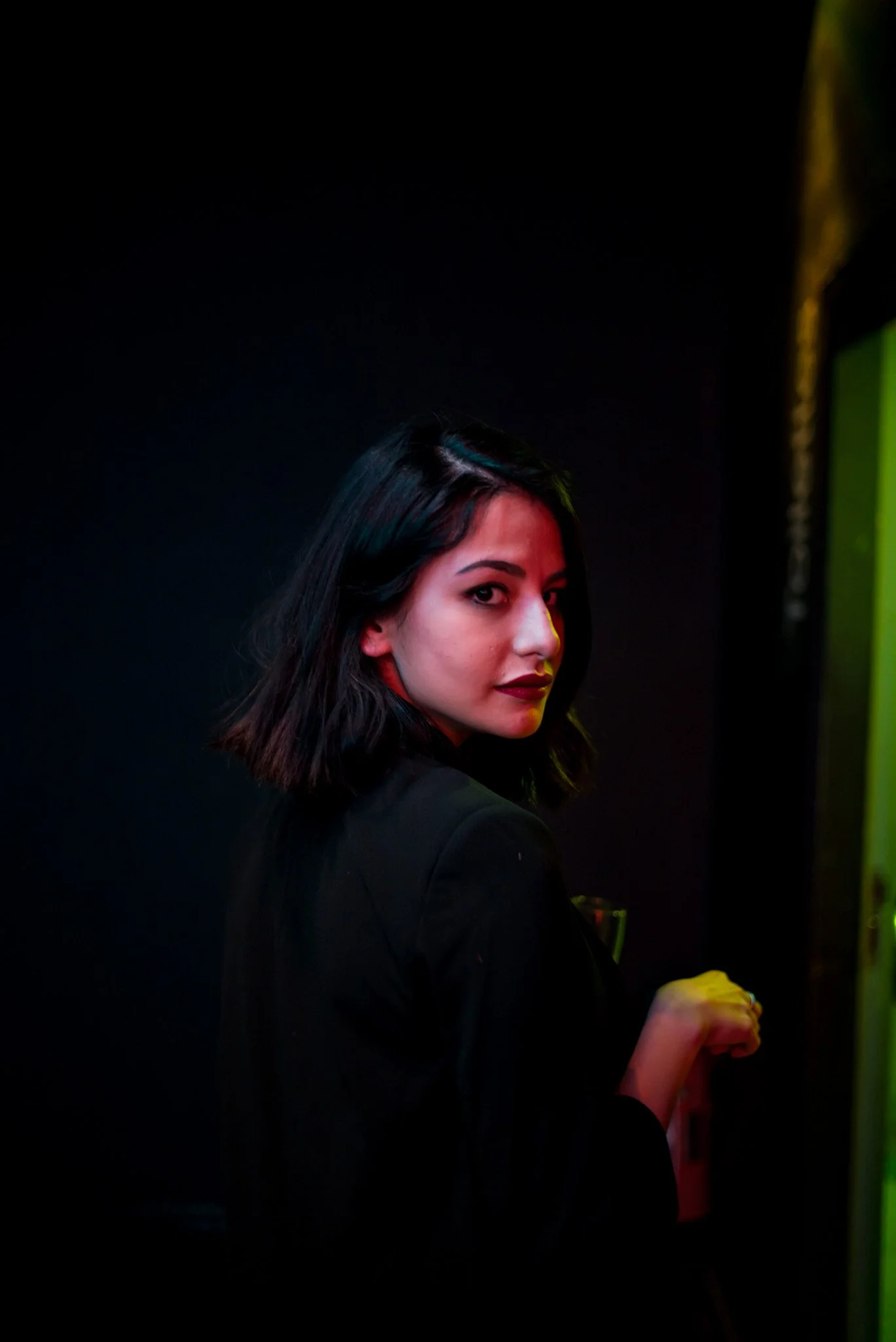 Portrait d'une invitée lors de l'événement Régus Paris. Elle regarde l'objectif avec assurance, dans un cadre sombre et sophistiqué, illustrant le style chic et moderne de la soirée d'entreprise.