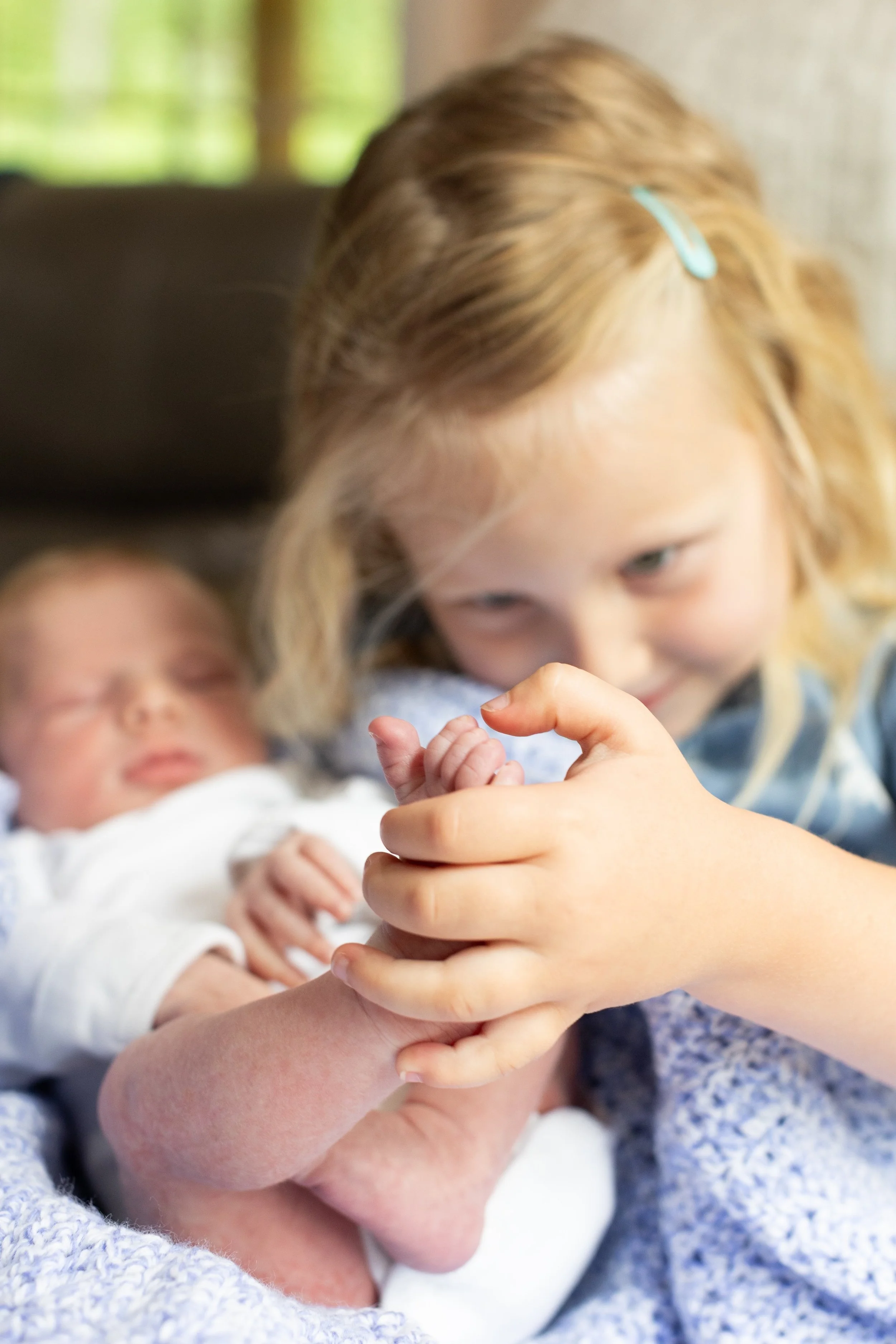 Newborn Sister Counting Toes.jpeg