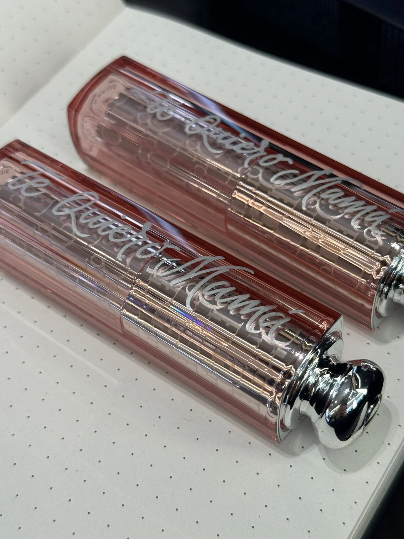 Lápiz labial en tono rosa con acabados metálicos, marca Dior. Están personalizados con caligrafía acrílica por Bendita Caligrafía..