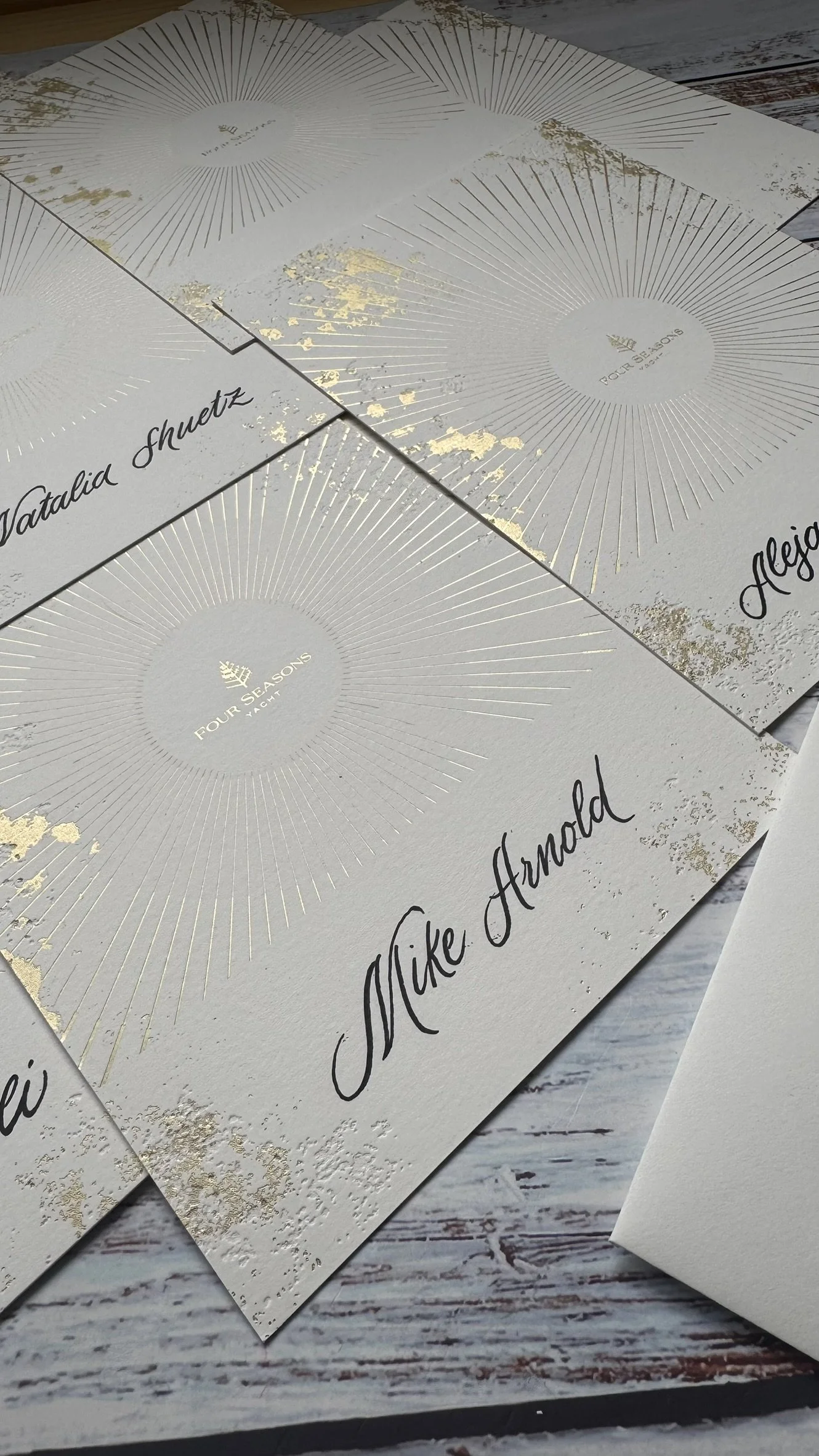Tarjetas blancas de un evento de Four Seasons caligrafiadas por Bendita Caligrafía.