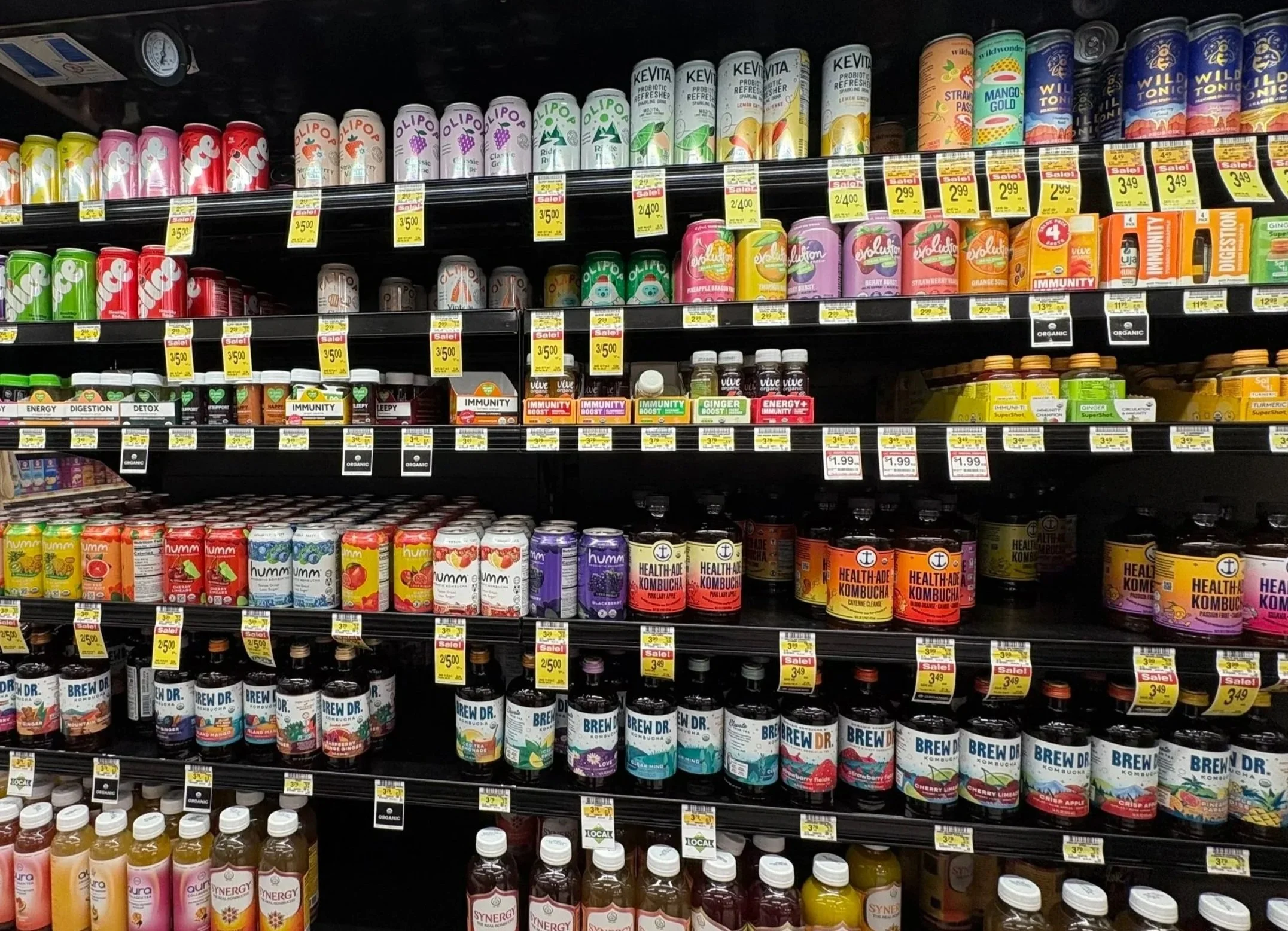 Crowded grocery store beverage shelf showing many competing drink brands side by side illustrating the competitive retail environment for CPG brands.