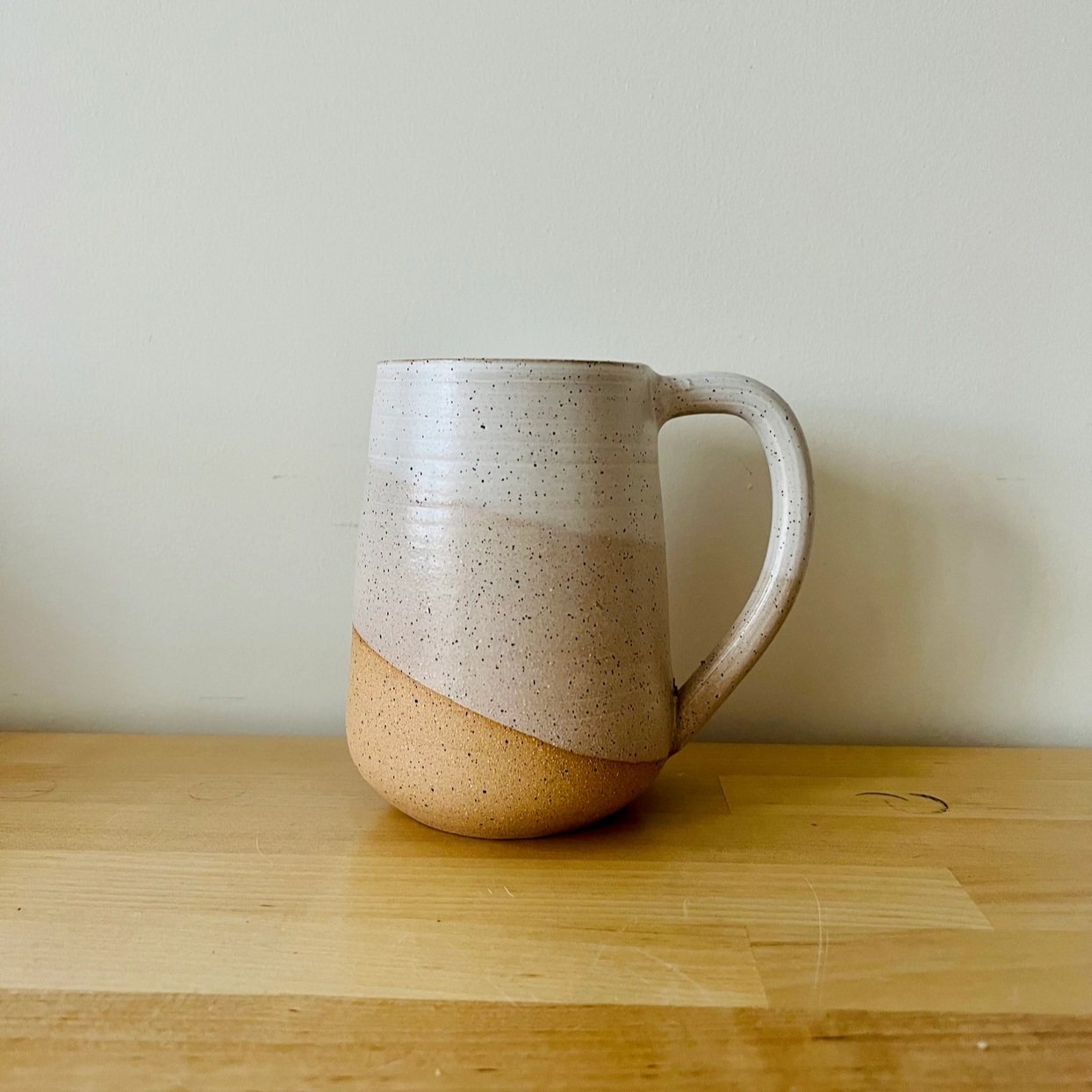 Tall Round-Bottom Mug with a layered warm white glaze and speckled finish, holding 16oz of your favorite beverage.