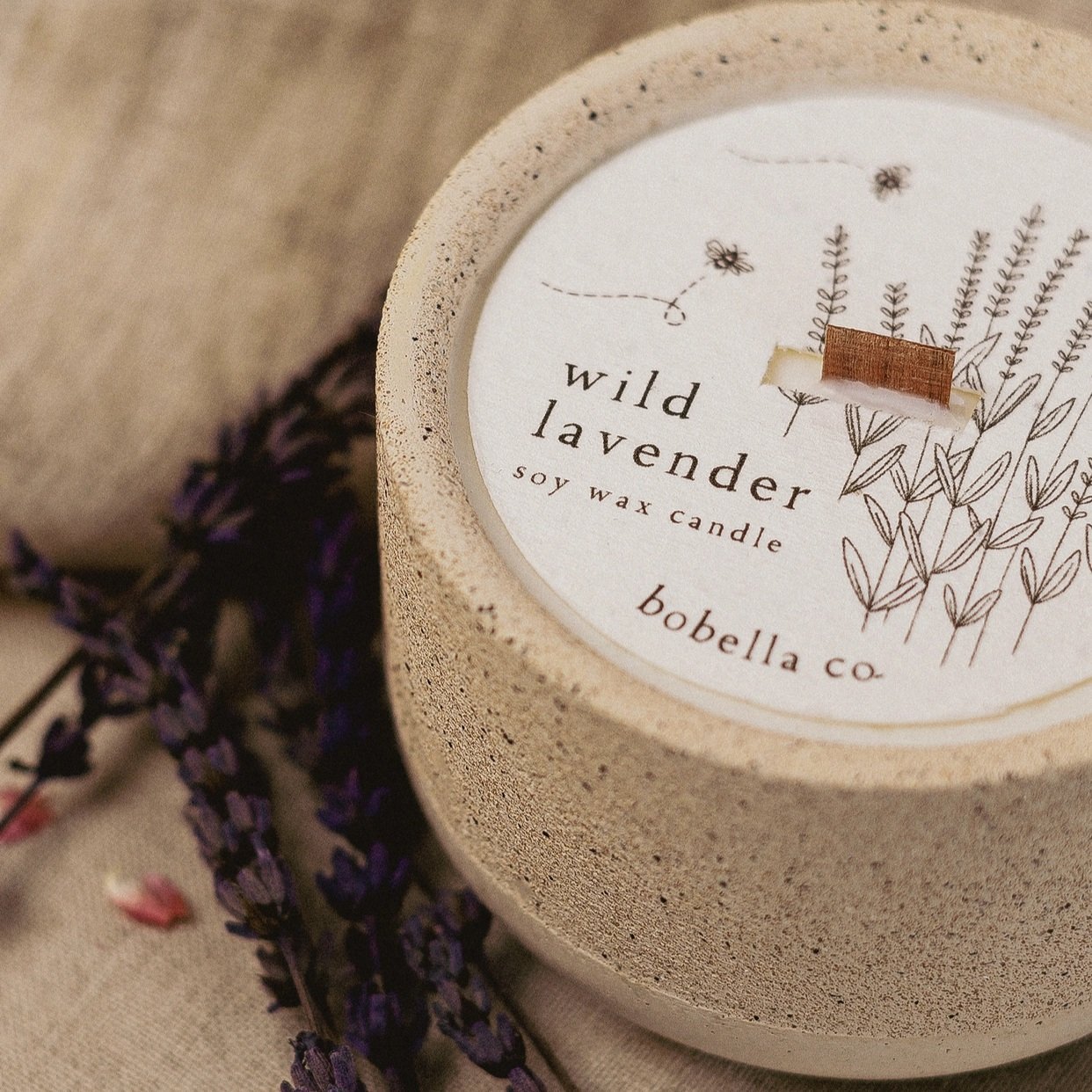 Hand-poured Wild Lavender soy wax candle in a speckled stoneware vessel with a plantable wildflower dust cover.