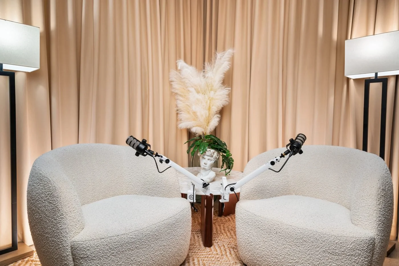 Curtain backdrop with two white chairs for interviews and podcast conversations.