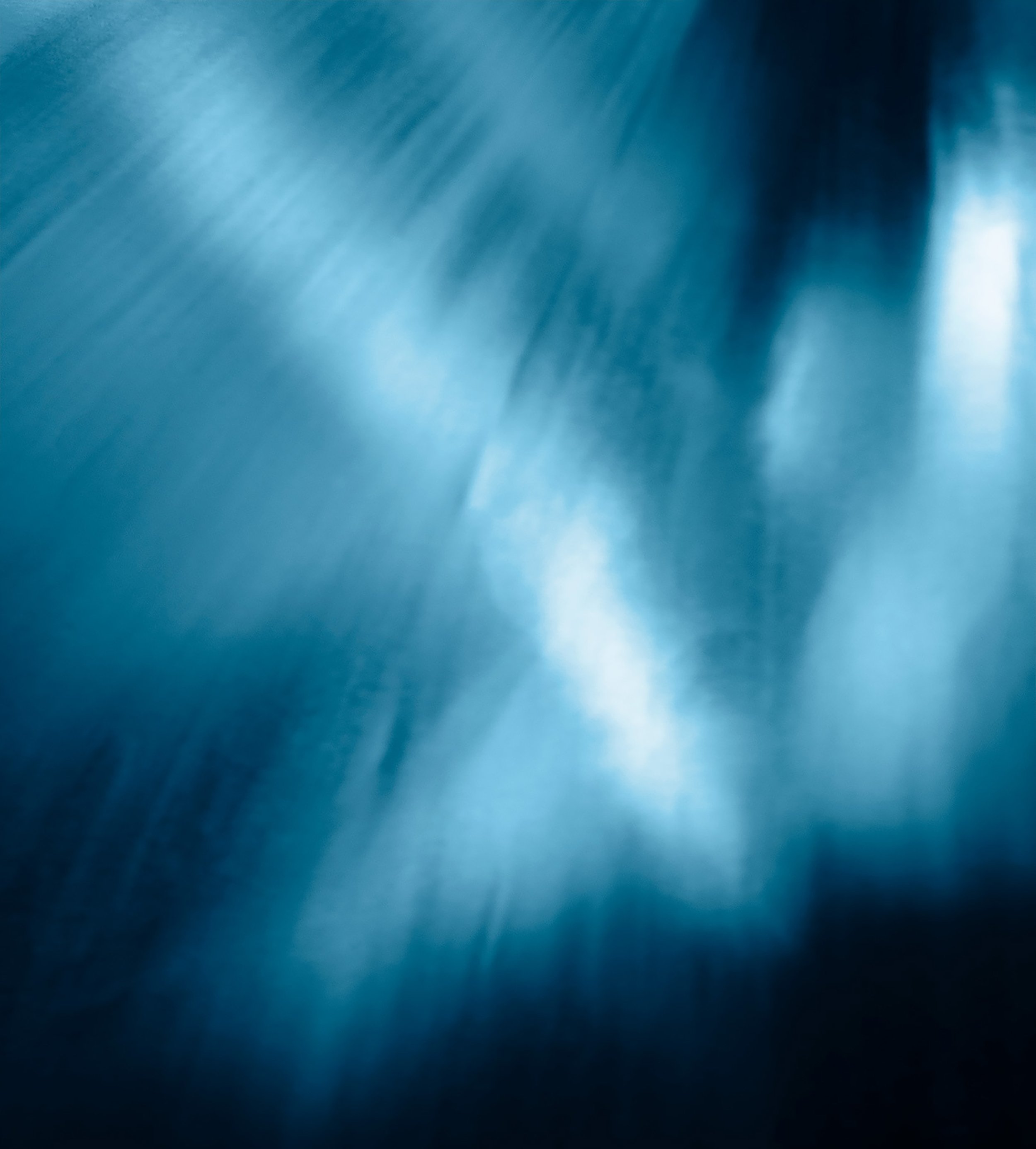 Close-up of a shiny, blue metallic surface with light reflections and shadows.
