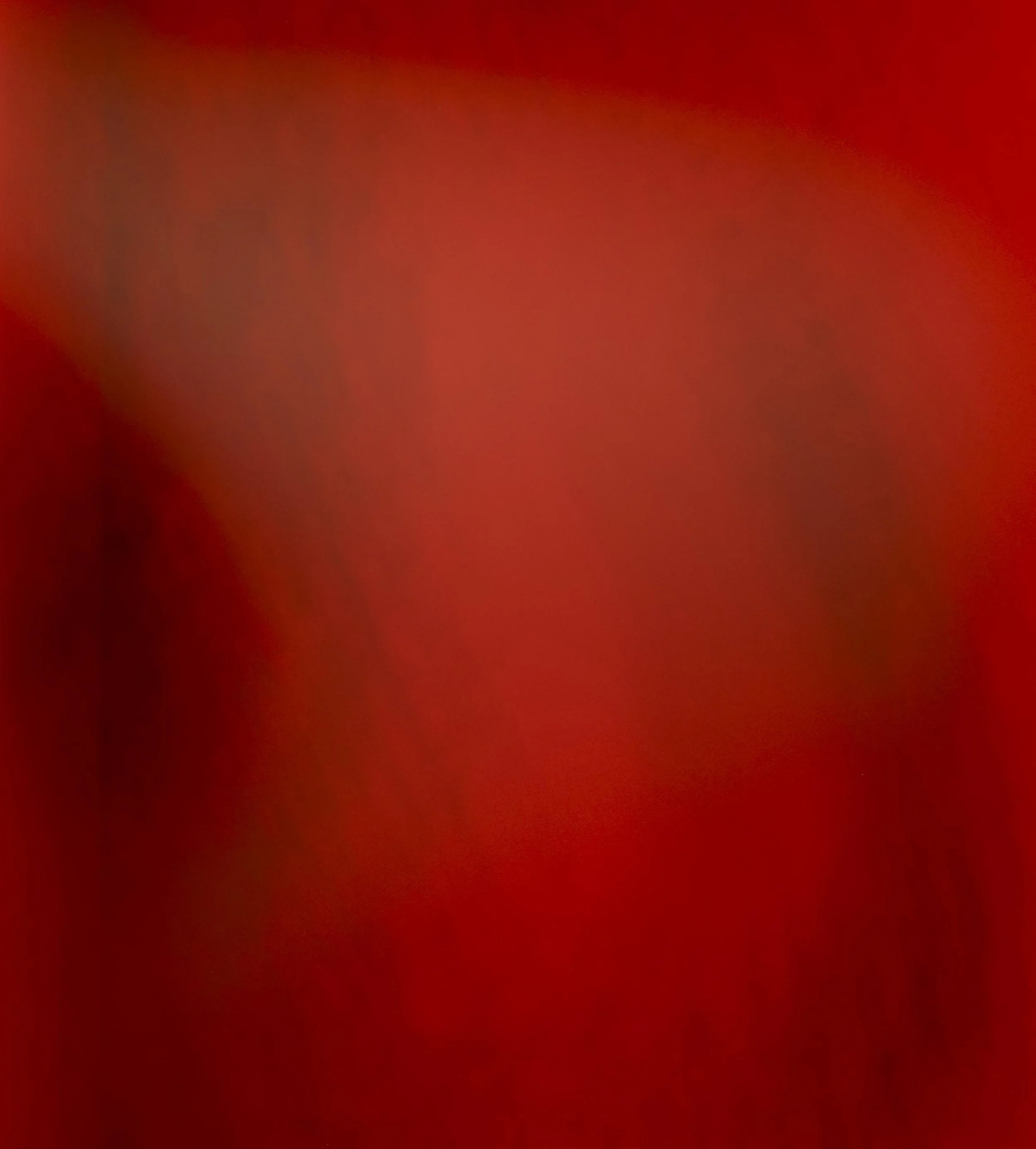 Very blurry image with red and black colors, no discernible objects or details.