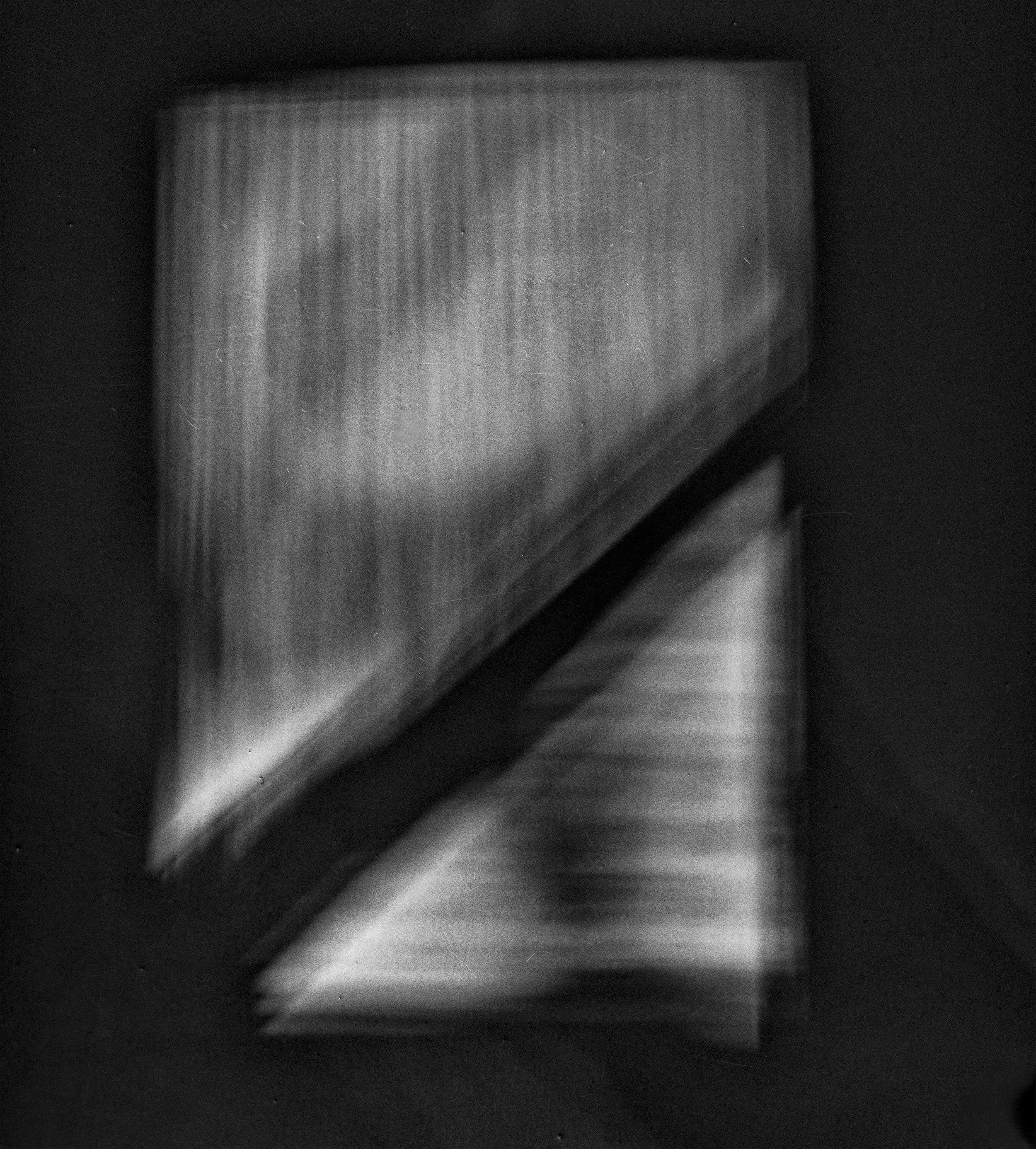 Close-up black and white photo of a textured wooden surface with dark framing around it.