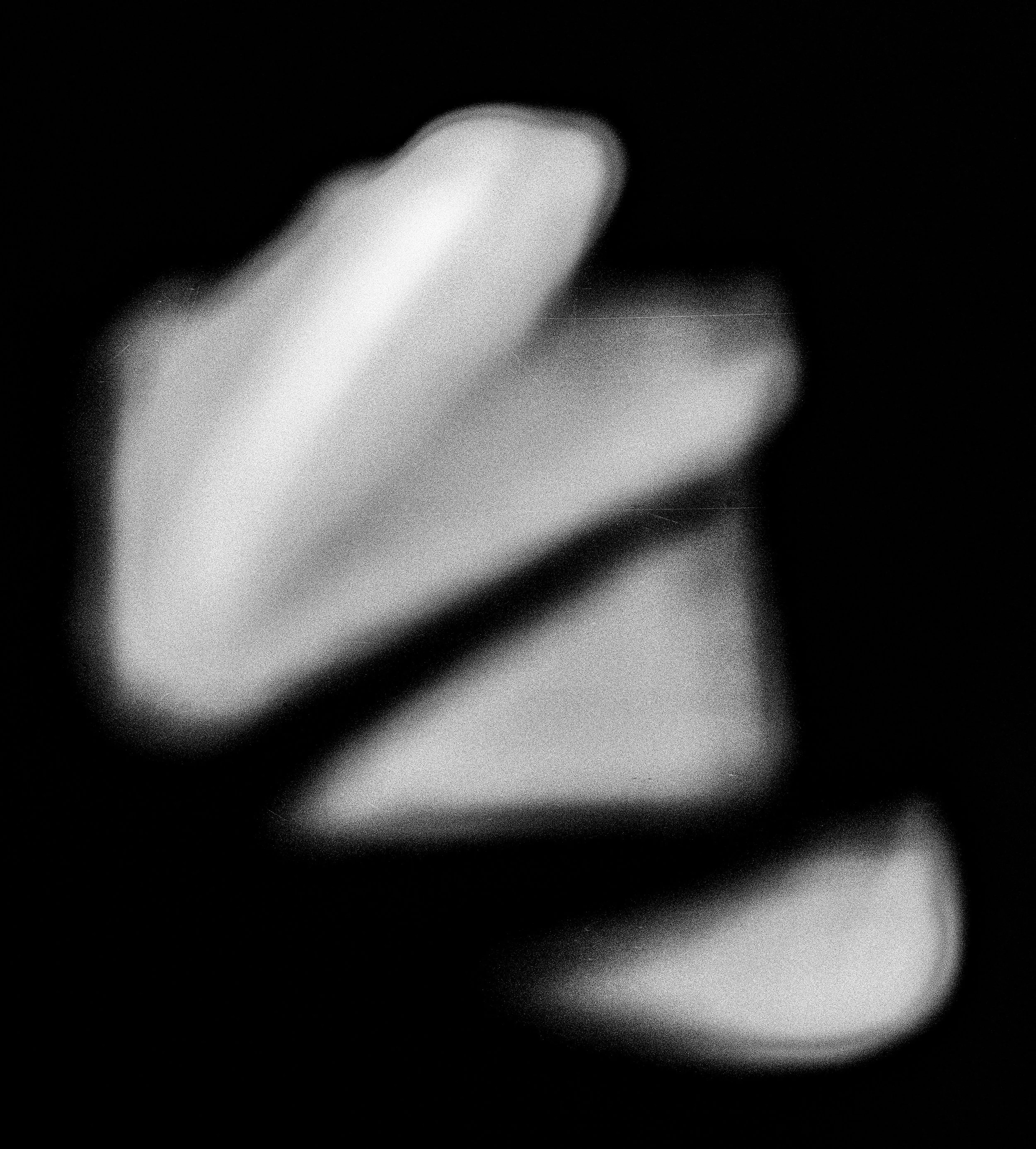 Black and white abstract image of a hand with the index finger pointing upward, set against a dark background.