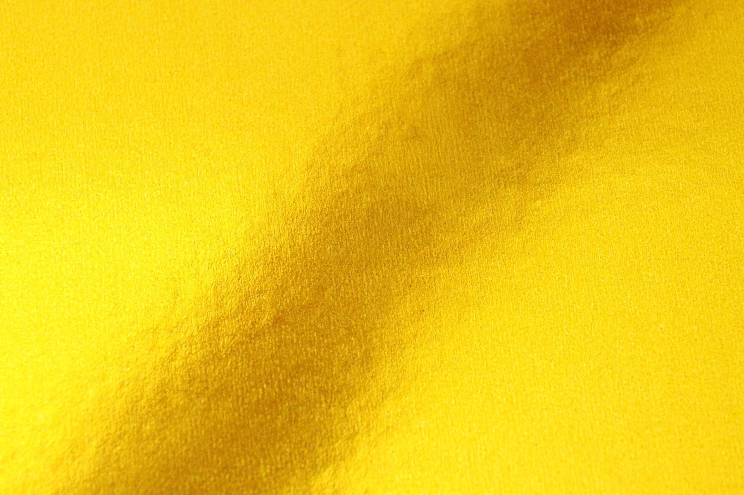 Close-up of a yellow textured fabric surface.