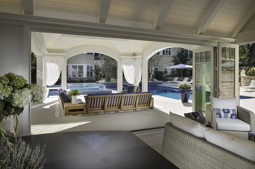 Covered loggia with outdoor sofas looking back toward the house