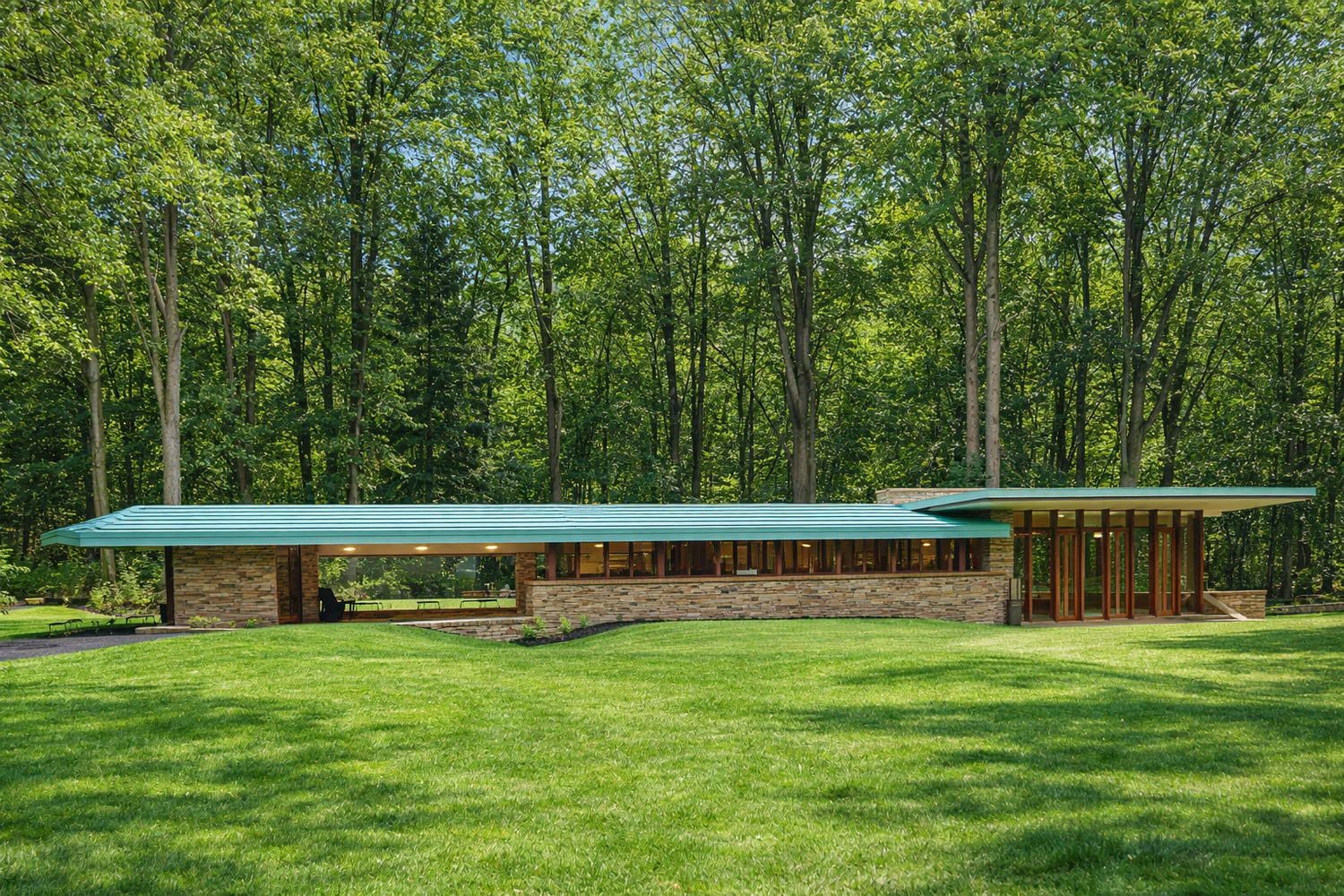 RiverRock seen long and low across a green lawn at the edge of a forest