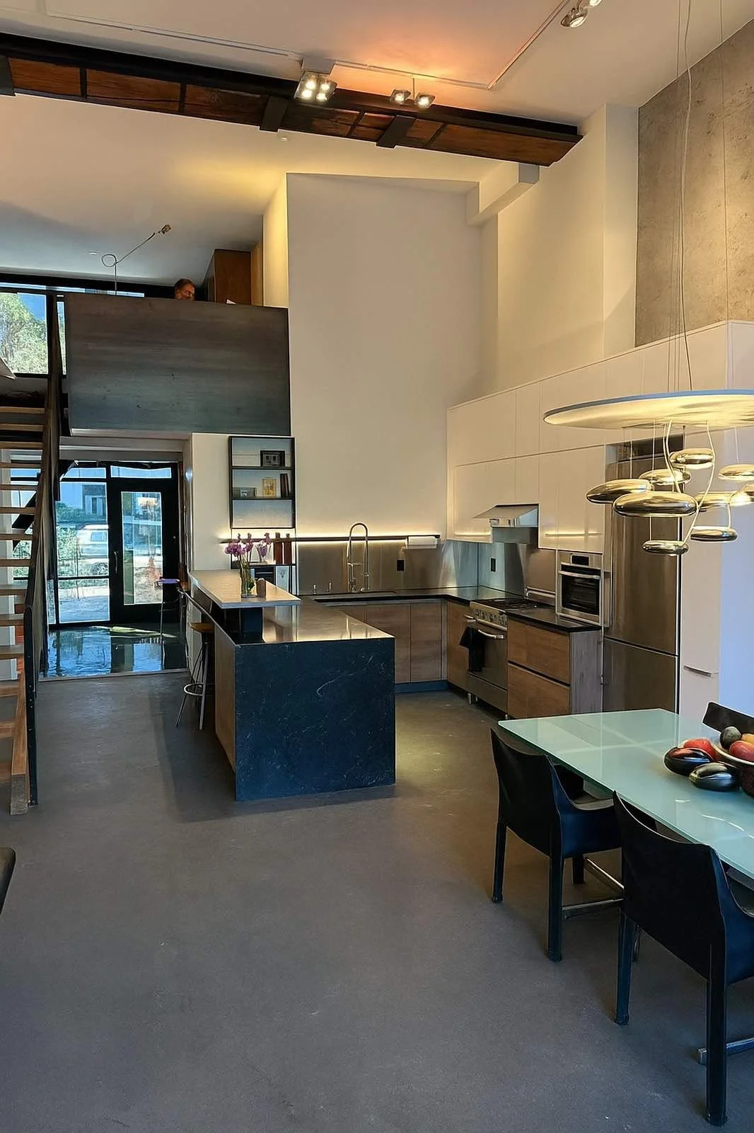 San Francisco loft kitchen with a dark island, stainless counters and an exposed steel beam