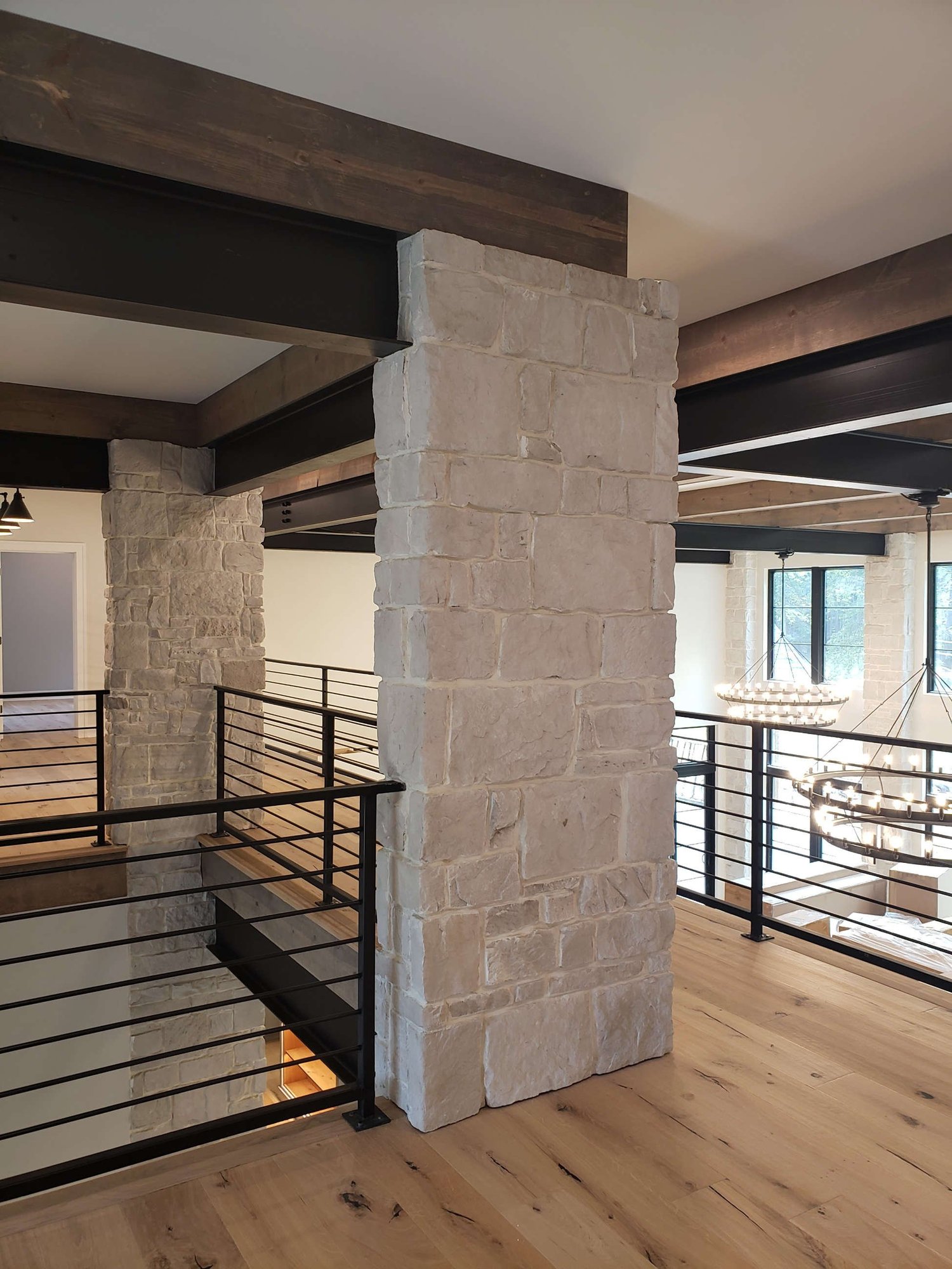 Upstairs gallery with stone column and steel railing