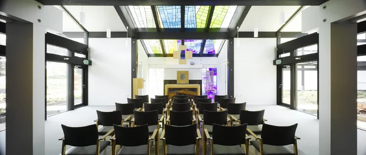 The chapel, with rows of chairs facing the altar and colored glass set into the roof