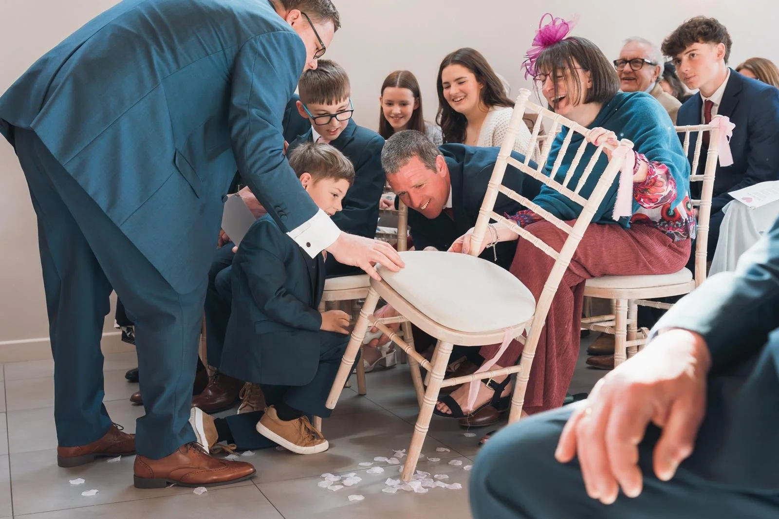 Son finds rings under his chair during surprise ring bearer moment within a celebrant led wedding ceremony at Gellifawr Woodland Retreat, Wales. 
Photo: Browne & Dixon Photography