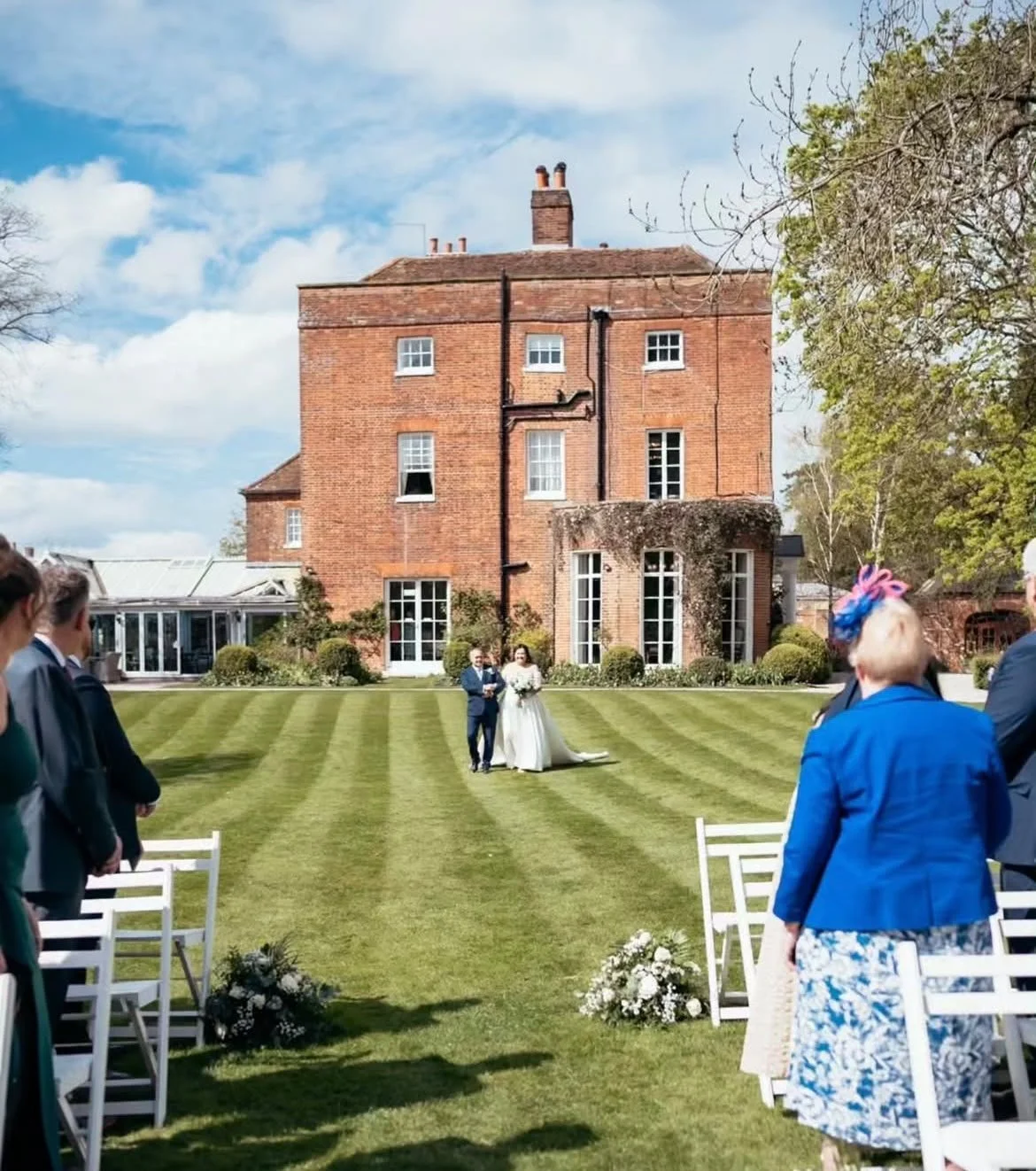 Bride walks down the aisle with her dad at Essex wedding venue, Mulberry House. She walks towards her groom and wedding celebrant based in Surrey who has created a personal wedding ceremony for them. 
Photo: Eyebrow Photography