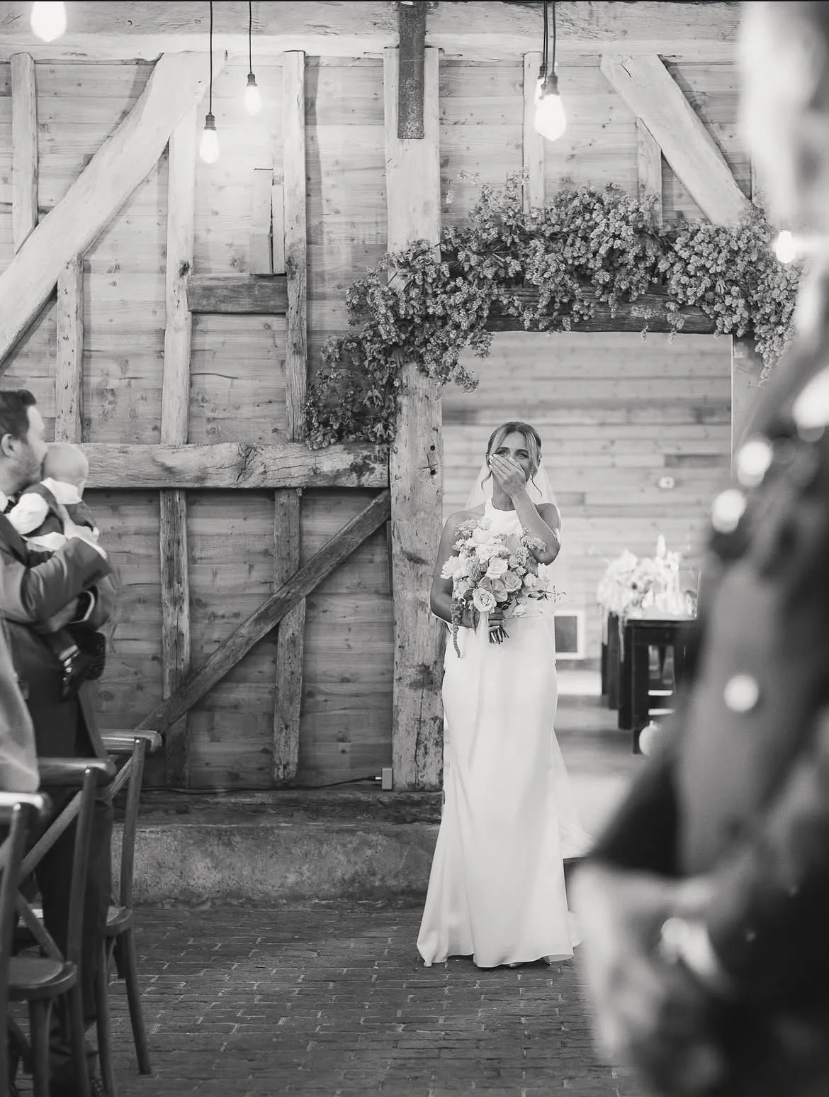 A beautiful bride walking down the aisle during a wedding ceremony at High Billinghurst Farm, led by an independent Surrey wedding celebrant, creating a relaxed and personalised celebration. Photo: Leanne Peacock Photography