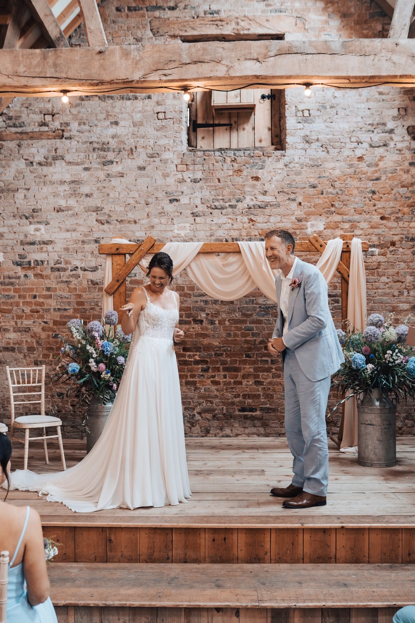 Laughing couple during personal vows at celebrant-led wedding ceremony by Surrey Wedding Celebrant at Milton End Barns, The Cotswolds. Photo: Paul Cuthbertson