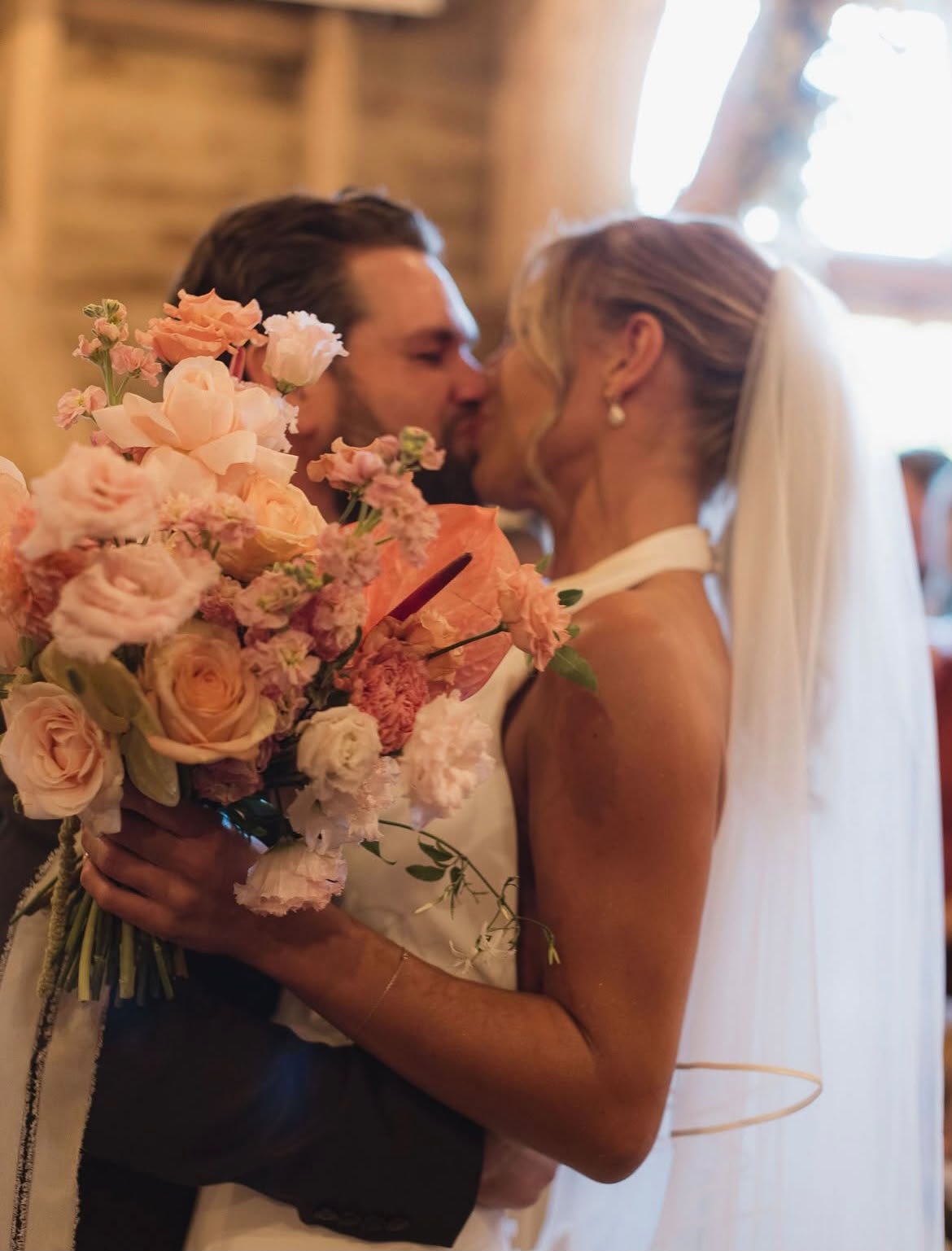 Bride and groom kiss to celebrate their laughter-filled and joyful wedding ceremony at High Billinghurst Farm, led by an independent Surrey wedding celebrant. Photo: Leanne Peacock Photography
