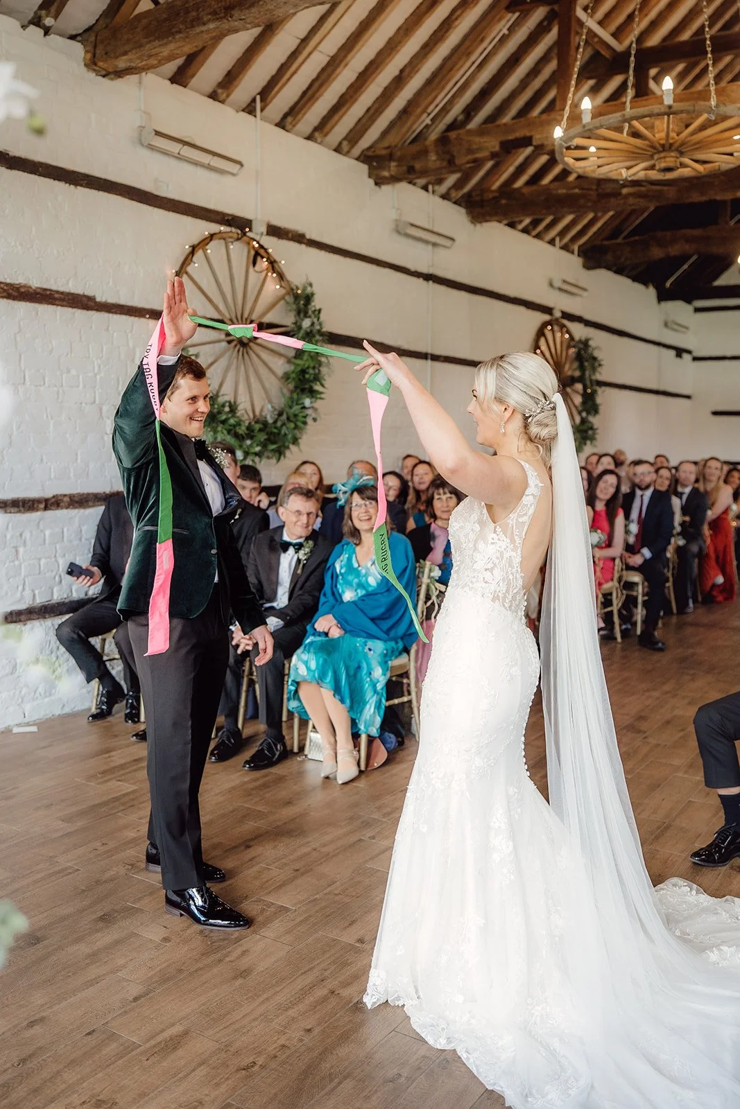 Couple take part in a handfasting ritual in a celebrant le-wedding ceremony by an independent Surrey based wedding celebrant. Photo: Amy  Diana Photography
