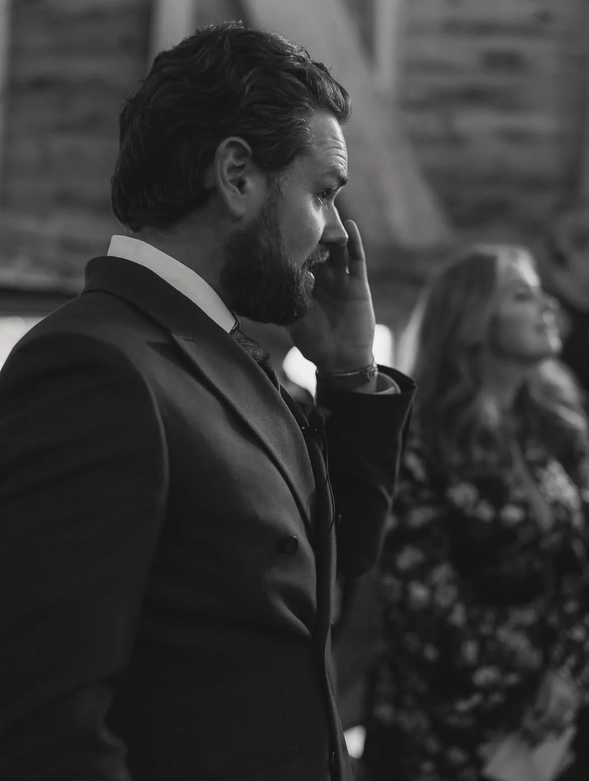 A handsome groom watching his bride walk down the aisle during a wedding ceremony at High Billinghurst Farm, led by an independent Surrey wedding celebrant, creating a relaxed and personal celebration. Photo: Leanne Peacock Photography