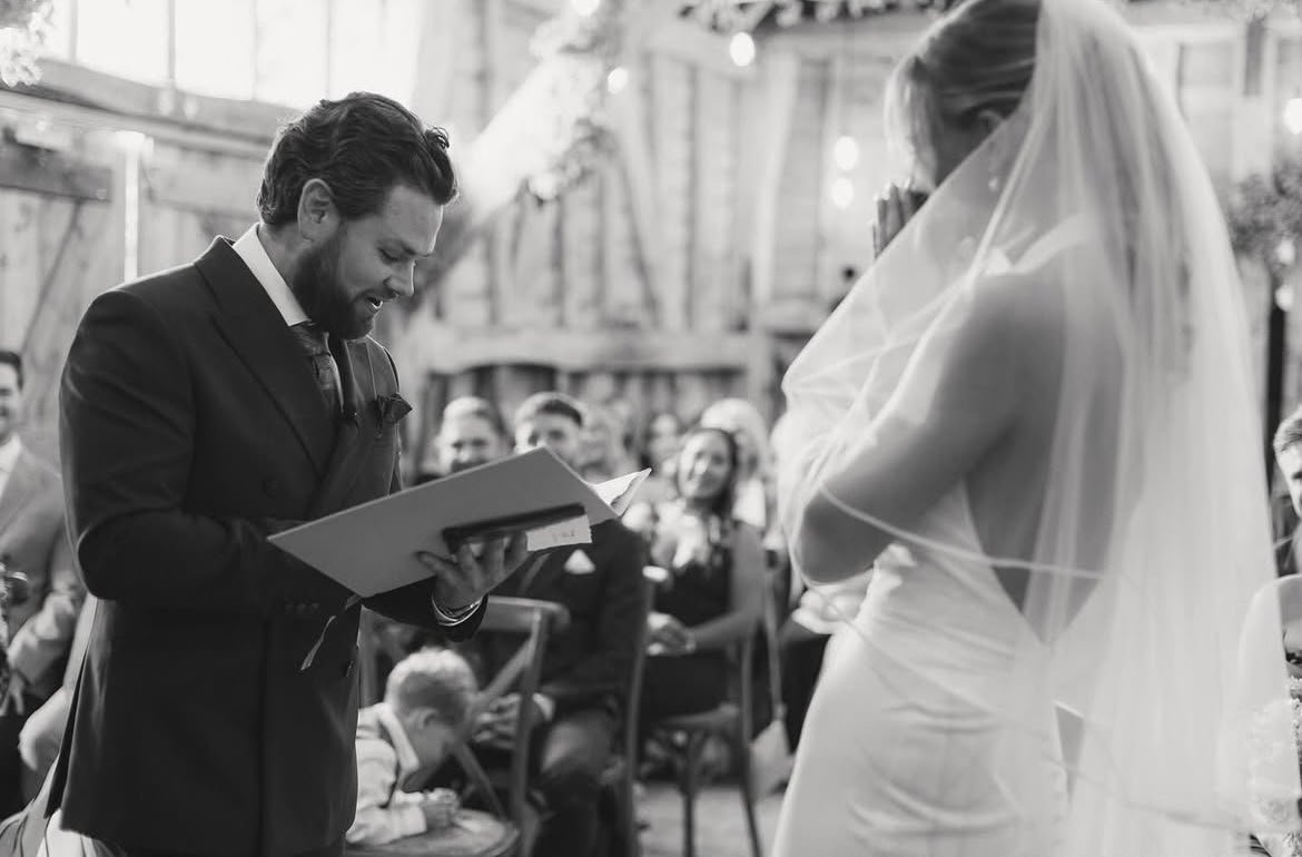 A couple celebrate their wedding ceremony at High Billinghurst Farm, led by an independent Surrey wedding celebrant, creating a relaxed and personalised celebration with family and friends. Photo: Leanne Peacock Photography