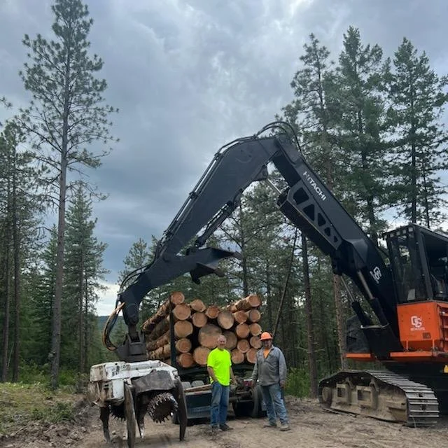 Partons with log loader and load of logs.
