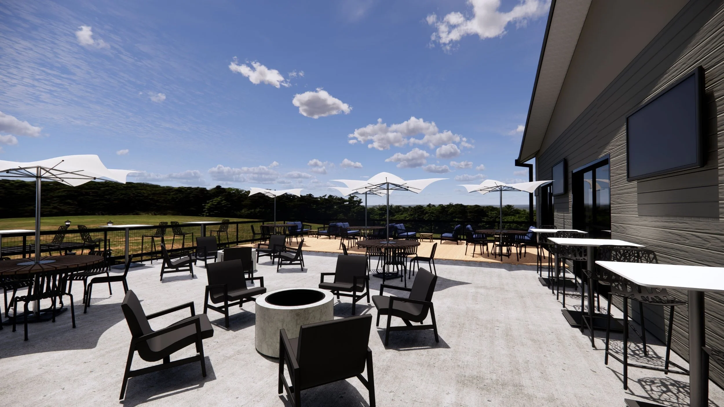 An outdoor patio area with black chairs and tables, white umbrellas, and a railing overlooking a grassy field with trees under a blue sky with scattered clouds.