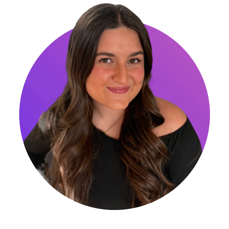 Portrait of a young woman with long brown hair, wearing a black off-shoulder top, smiling against a purple background.