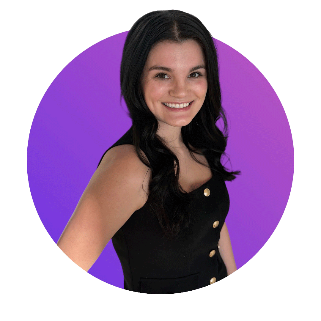 A woman with long black hair, smiling, in a black sleeveless dress with gold buttons, standing in front of a purple background.