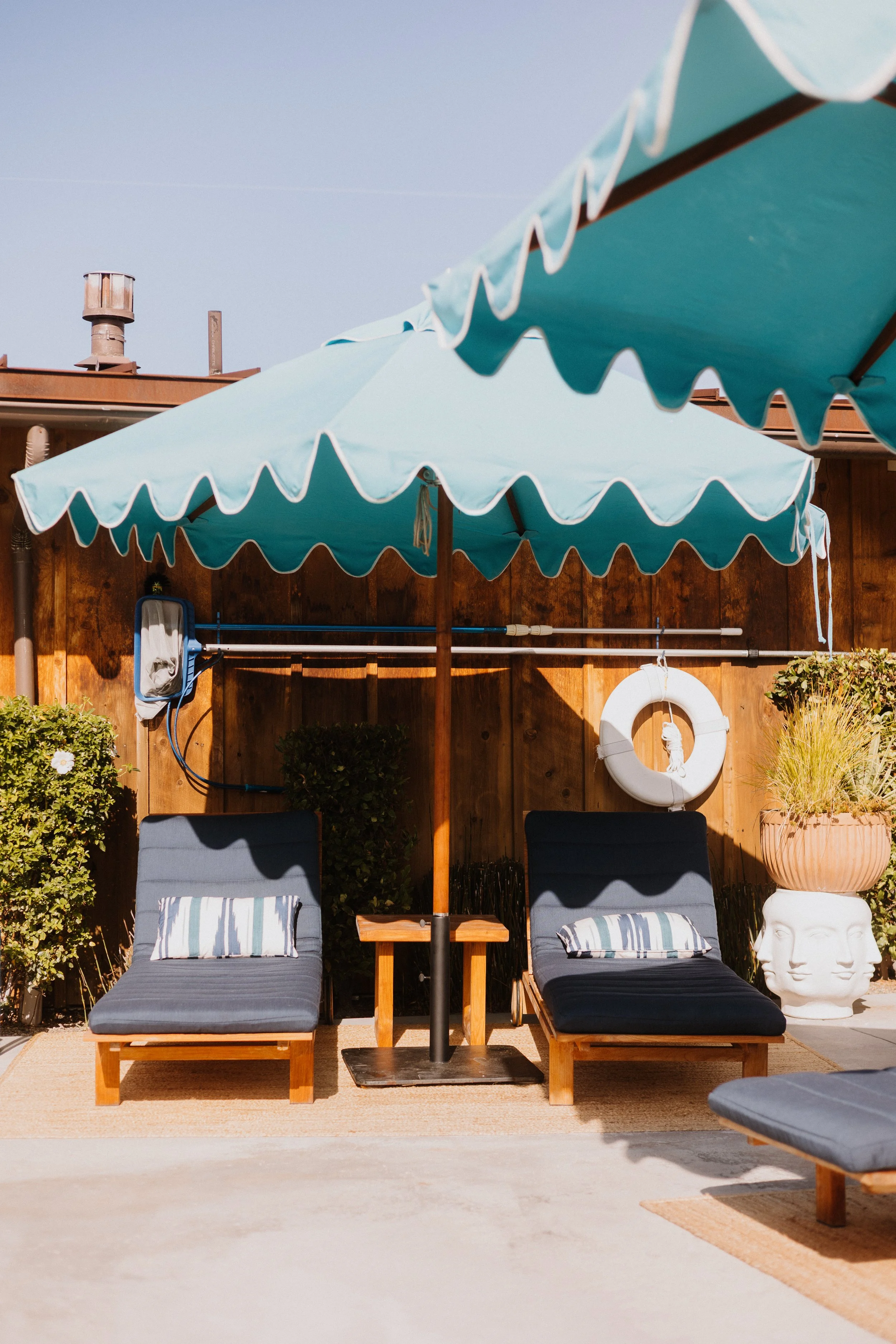 Lounge chairs by heated pool with food and drinks at Skyview Los Alamos